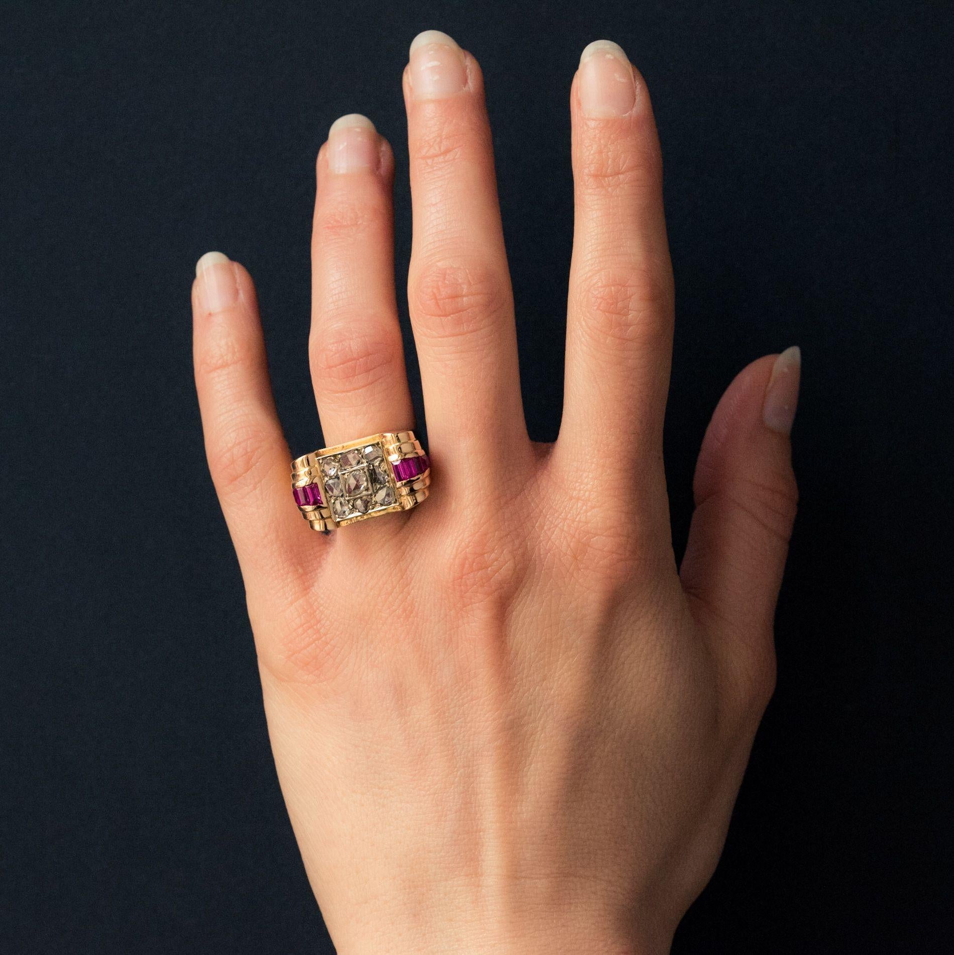 Ring in 18 carat yellow gold. 
This geometric ring is set with rose cut diamonds enhanced with a bow studded with antique cut diamonds and calibrated red gems. 
Total diamonds weight: 0,75 carat approximately.
Height: 13.3 mm, width: 23.7 mm,