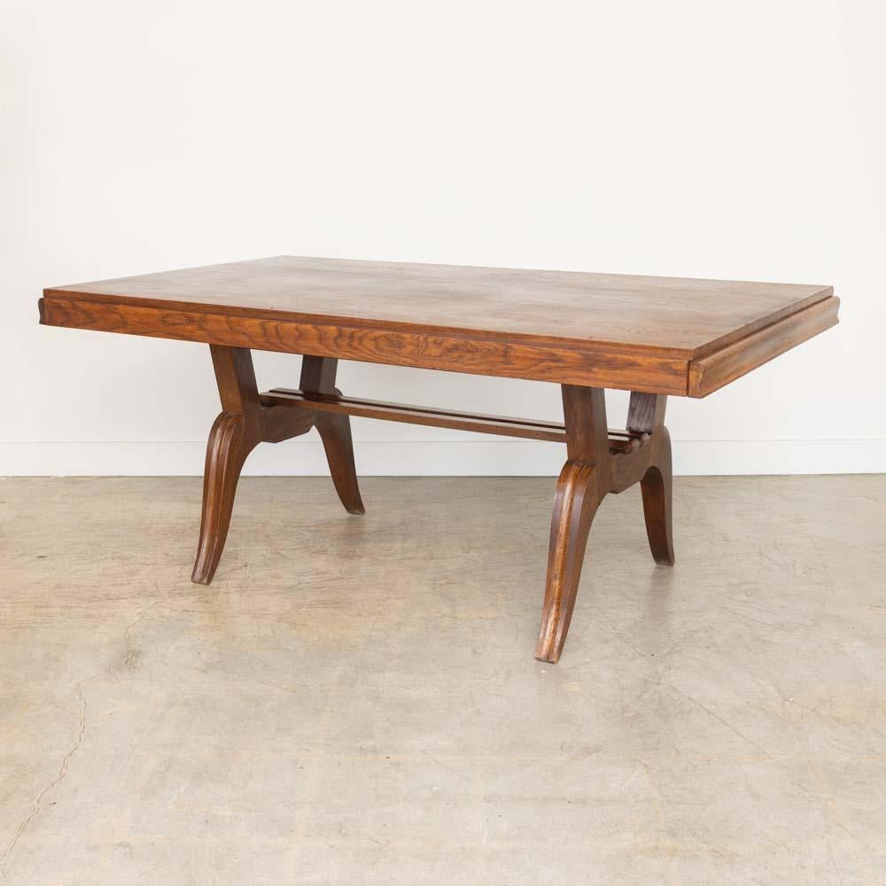 Incredibile tavolo da pranzo in legno proveniente dalla Francia, anni '40. Ampio piano rettangolare in legno massiccio. Gambe scultoree in legno curvato con dettagli a coste sul telaio. La finitura originale del legno presenta una bella patina e