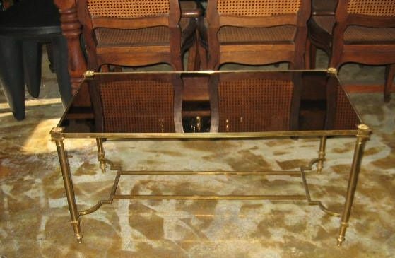Table basse magnifiquement conçue avec un plateau original en bronze antiqué et en miroir texturé. Le design néoclassique des montants et des pieds. Capuchons à rosettes sur les jambes.