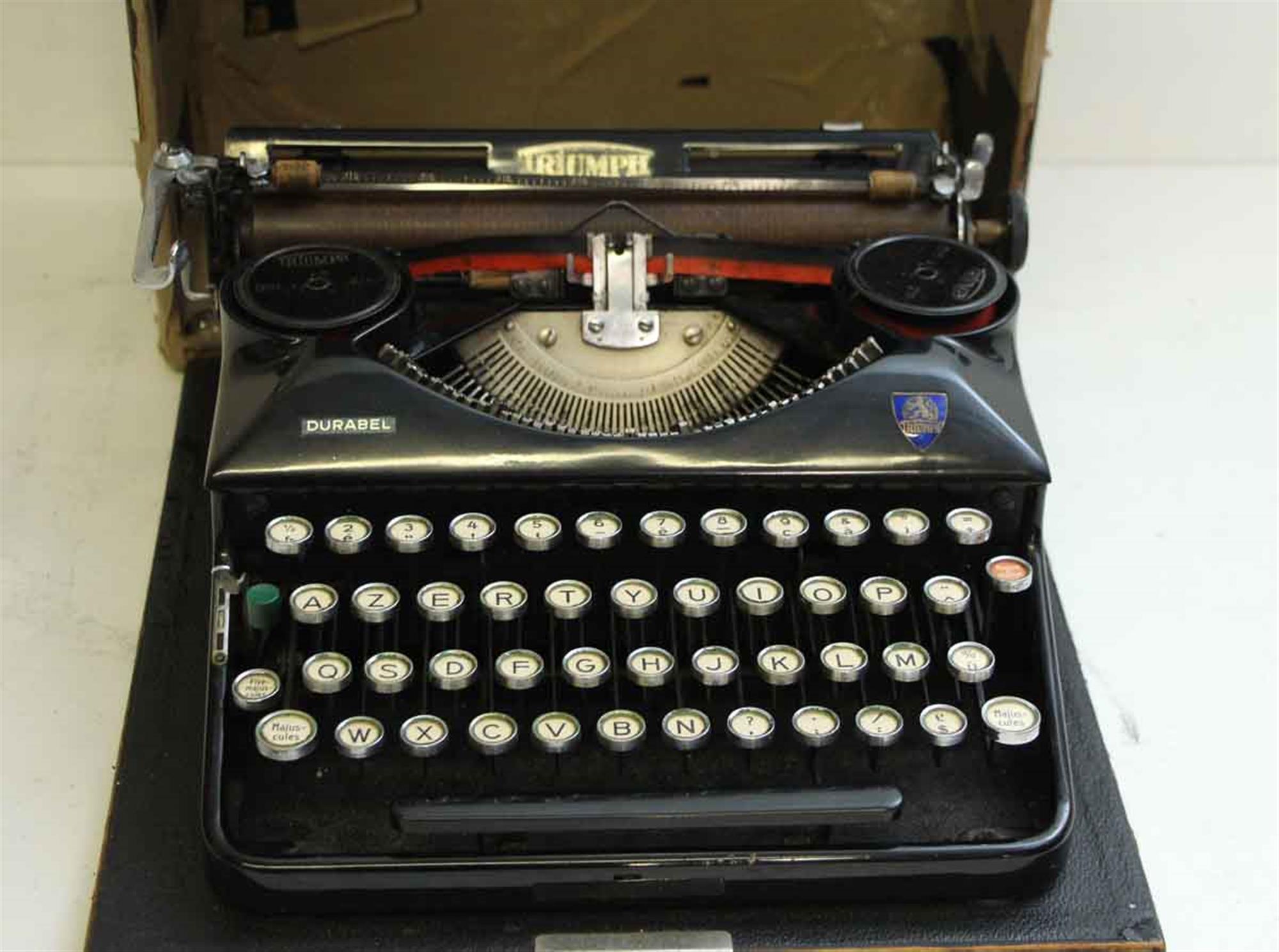 1940s French Triumph brand black vintage typewriter with original case. Please inquire about working condition. This can be seen at our 5 East 16th St location on Union Square in Manhattan.