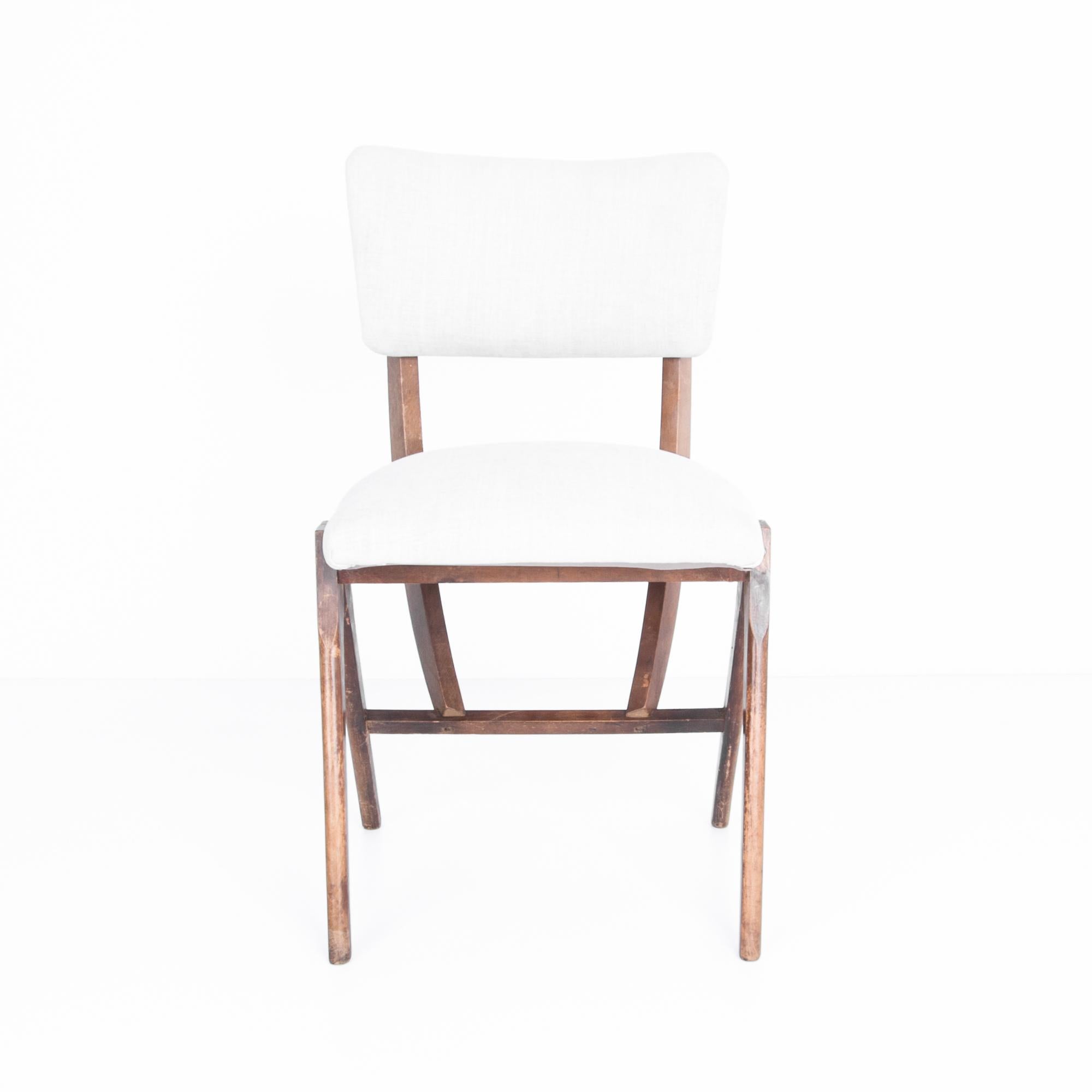 This curious design from France is a modernist simplification of the traditional side chair. Angled chair legs peak, creating a practical structure and dynamic geometry, connecting to the curved chair back. A distressed patina accentuates the