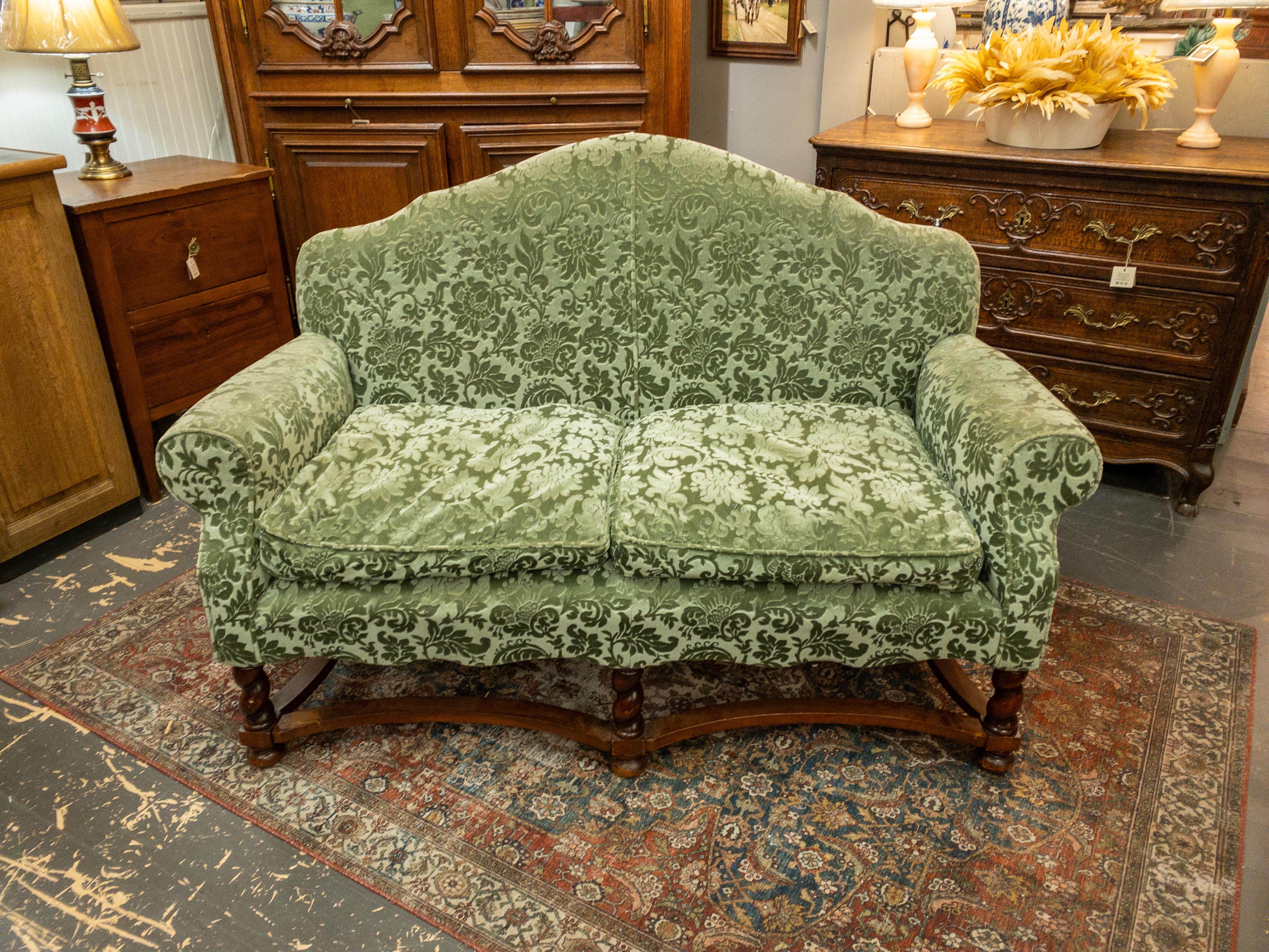 The 1940s French Upholstered Sofa epitomizes the epitome of sophistication and timeless elegance. Its exquisite craftsmanship is evident in every detail, from the intricately carved legs that boast delicate curves and ornate motifs, to the plush