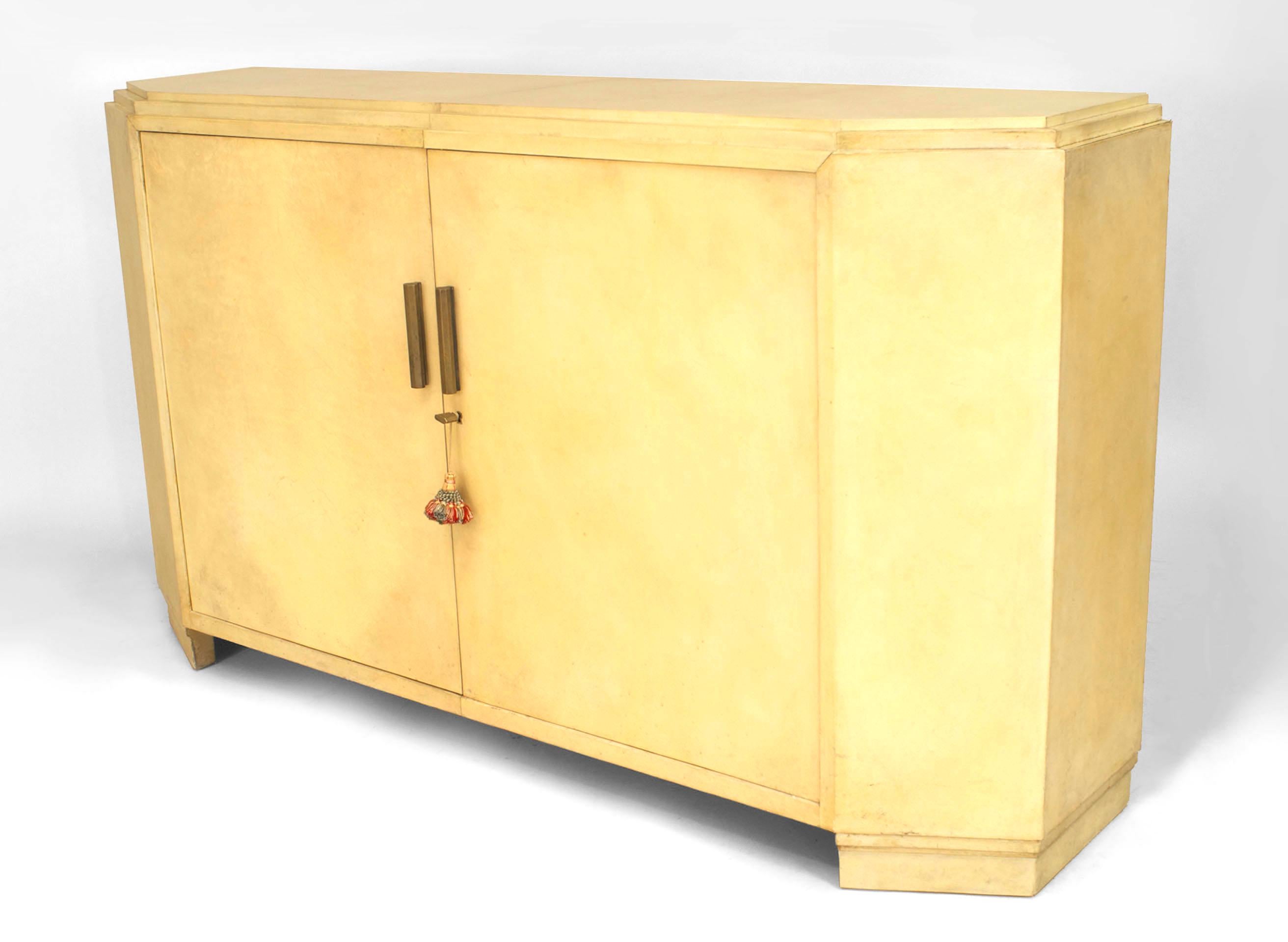 French Mid-Century (1940s) white parchment narrow sideboard cabinet with canted sides and a stepped up top with 2 front doors having bronze cylindrical handles.
