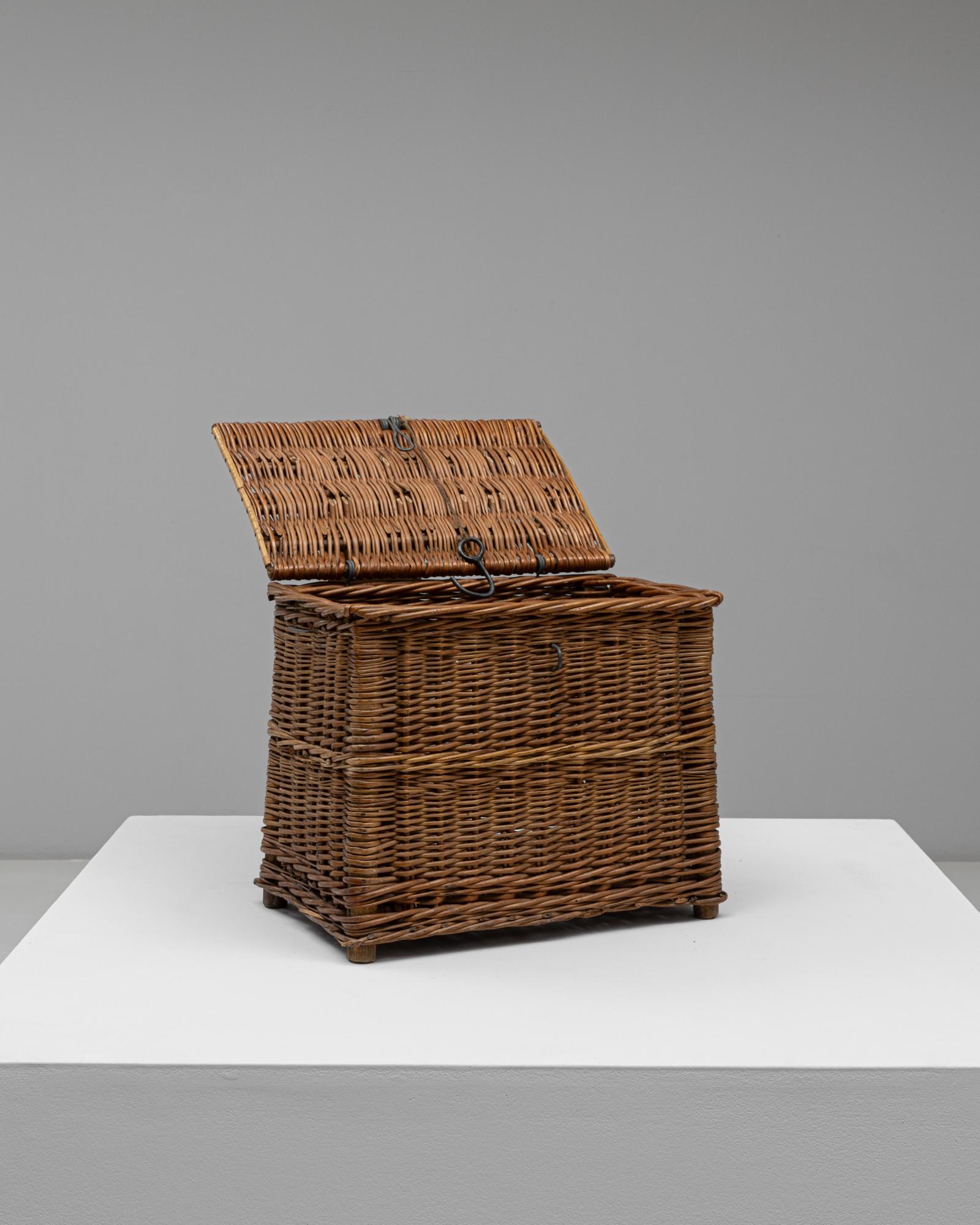 This 1940s French wicker basket captures the charm and practicality of mid-century French craftsmanship. Handwoven from natural wicker, it features a tight, durable weave with a warm honey patina that has aged beautifully over time. The hinged lid