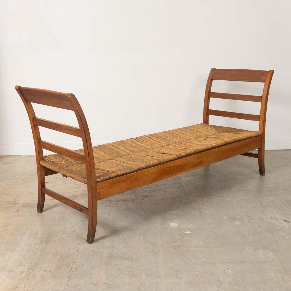 Incredible wood and woven daybed from France, 1940s. Long oak wood frame with lattice detail and woven rush seat. Original wood finish showing beautiful natural grain. Original woven rush seat shows areas of age and patina. Beautiful statement