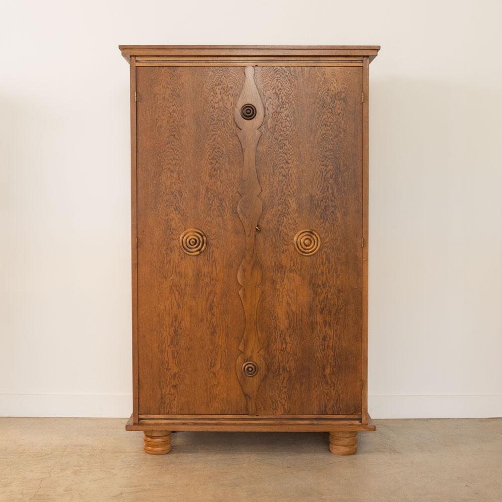 Incredibile mobile contenitore in legno intagliato di Charles Dudouyt, Francia, anni '40. Bellissimo dettaglio del cerchio in legno intagliato sulle due porte anteriori con disegno centrale ondulato. Serratura e chiave originali. Il mobile poggia su