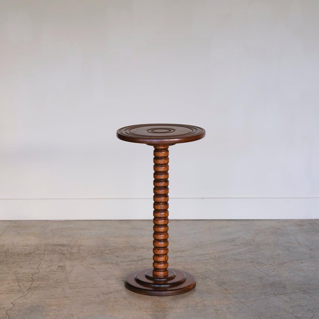 Beautiful carved oak table in the style of Charles Dudouyt from France, 1940's. Carved ribbed stem with circular top and base. Newly refinished in a medium oak stain. Perfect as a side table or drink table.