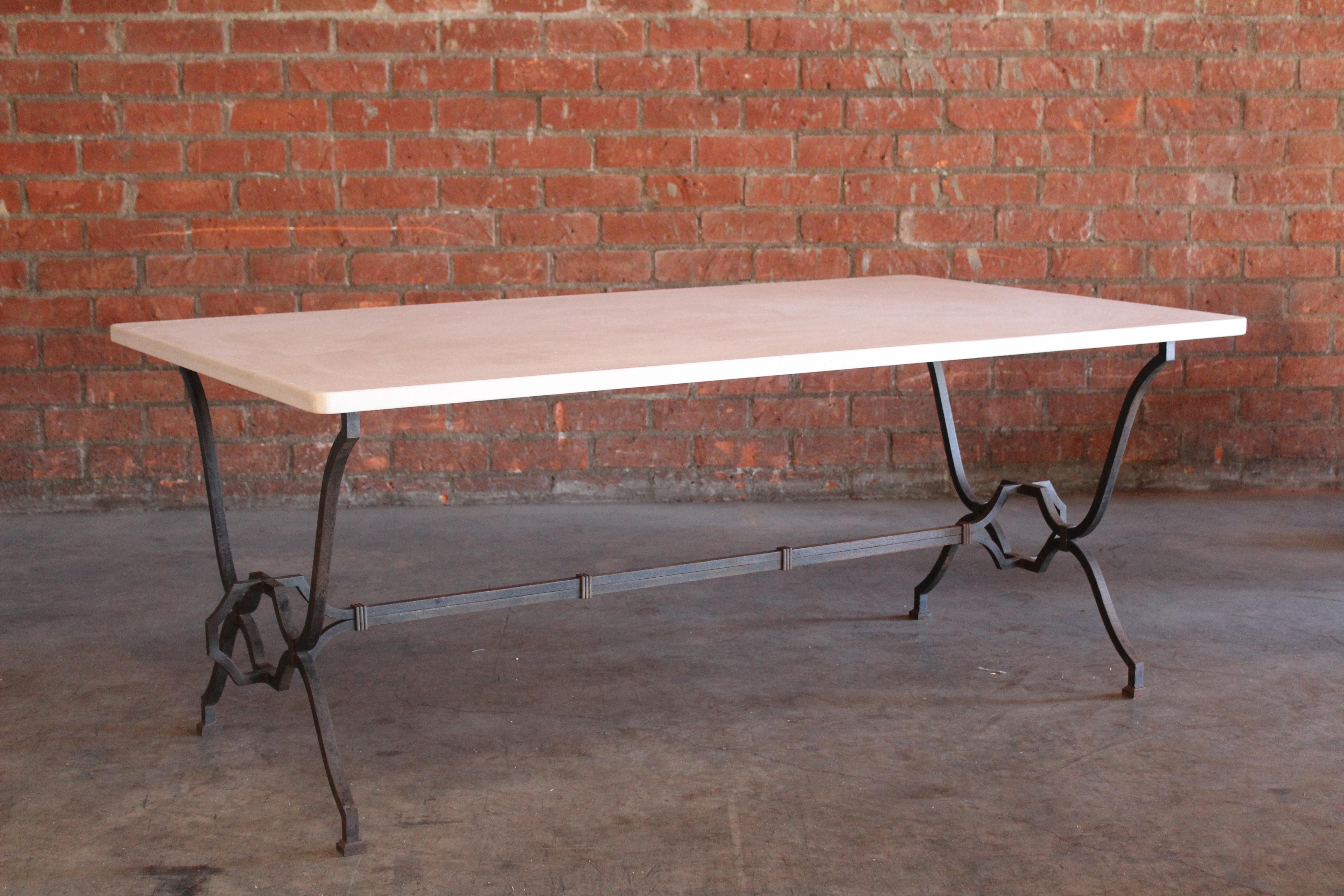 A vintage custom made dining table designed by French designer René Prou in the 1940s. Heavy wrouht iron with French limestone top. In excellent condition. Base shows patina. Measures: 70