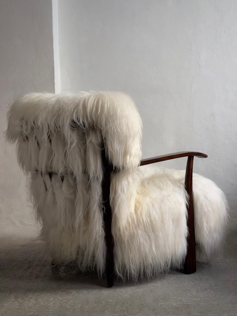 In the annals of mid-20th century design, this rare 1945 Fritz Hansen easy chair (model 1595) with long haired Icelandic sheepskin stands as a testament to the innovative spirit and exquisite craftsmanship that defined the era. Crafted by the