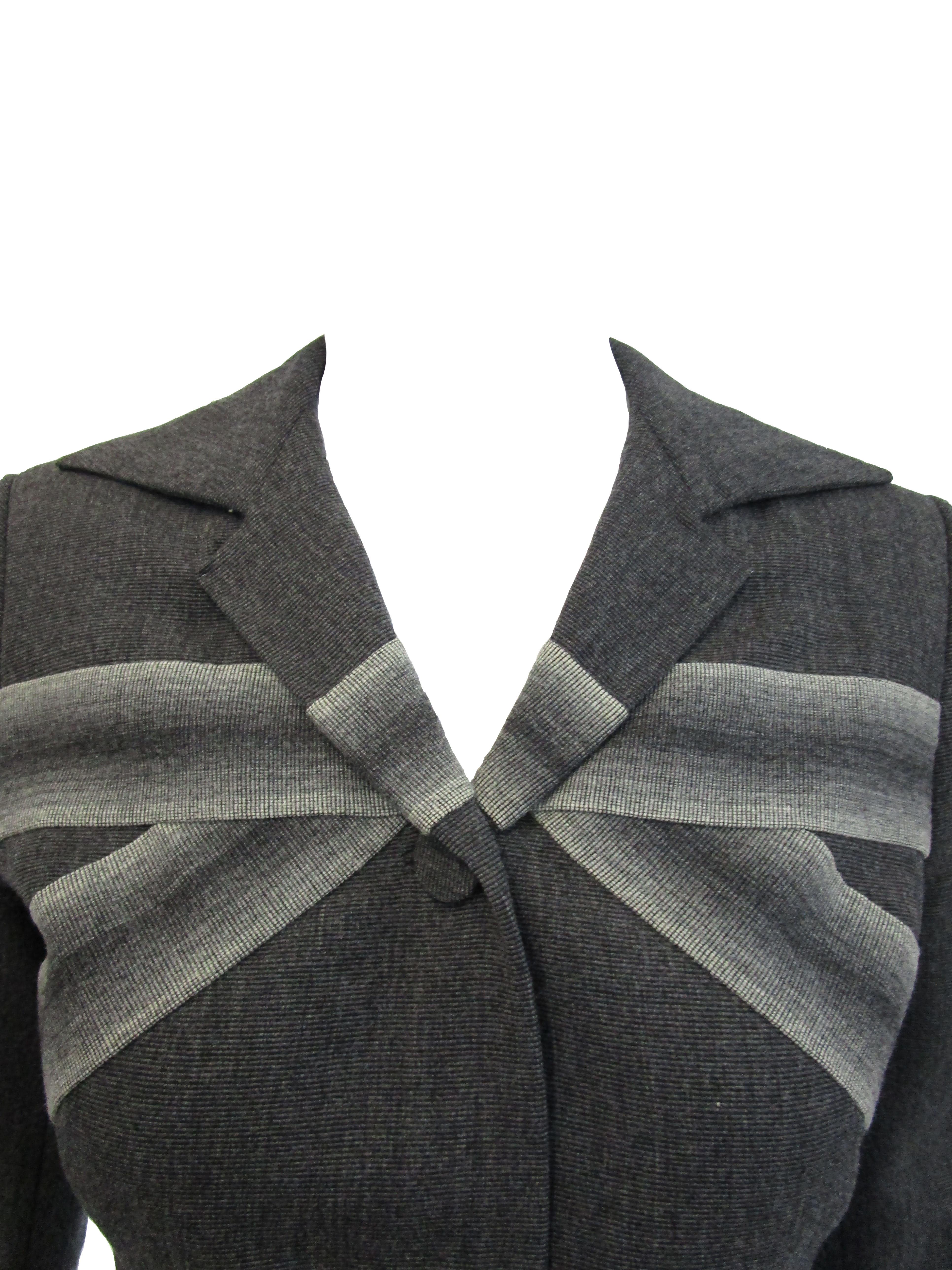 
Intriguing yet subtle blazer by great Hollywood designer, Adrian! This blazer features a slim cut and three large buttons. Two grey gradient stripes race across through each other and reconvene on the back of the blazer.  It is also fully lined in