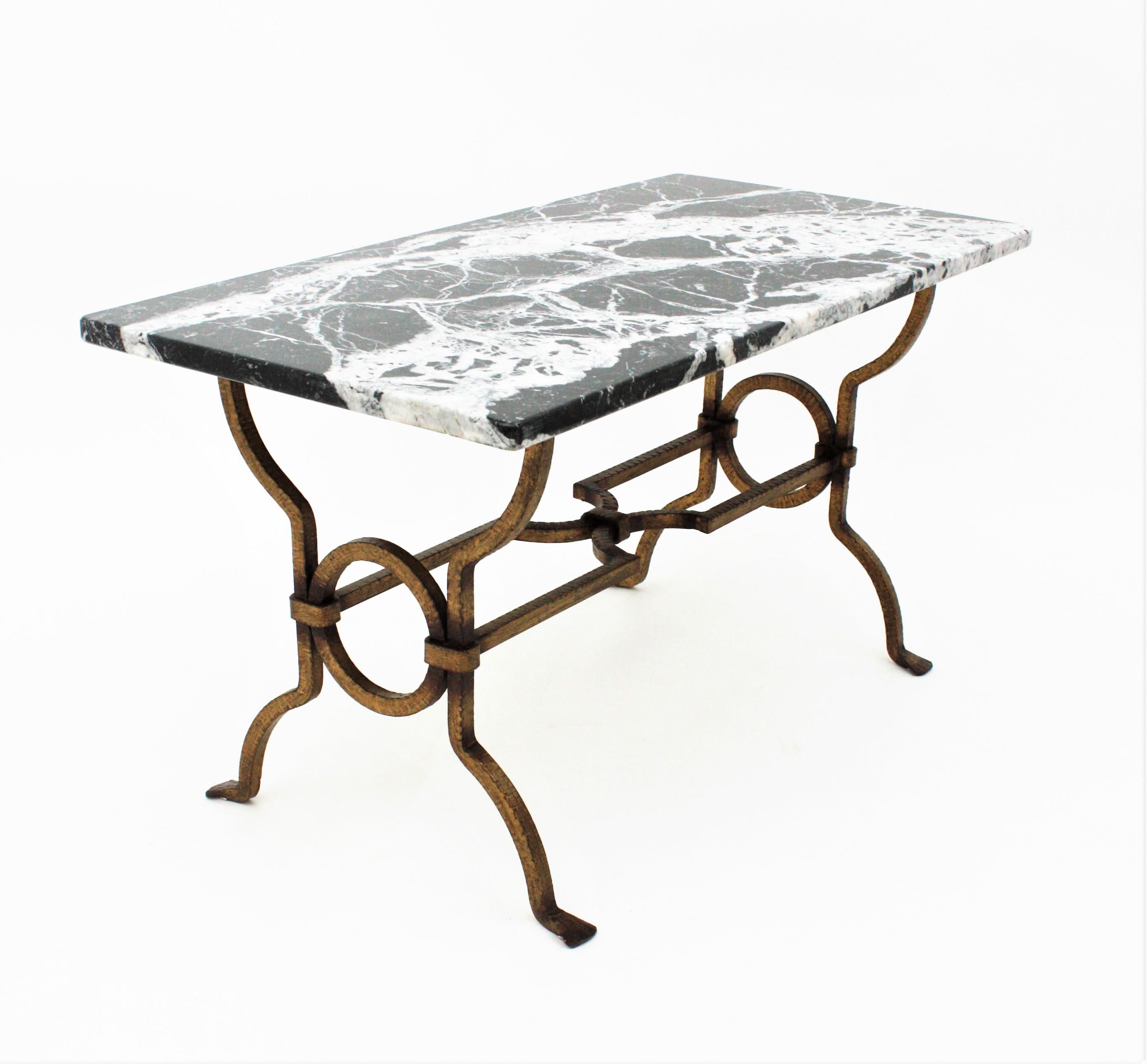 Beautiful Gilbert Poillerat wrought iron low table with black and white marble top. France, 1940s.
Stylish shapes and dramatic black marble top with white veins.
Excellent condition.
Original gold leaf gilt and beautiful aged patina.
Use it as low