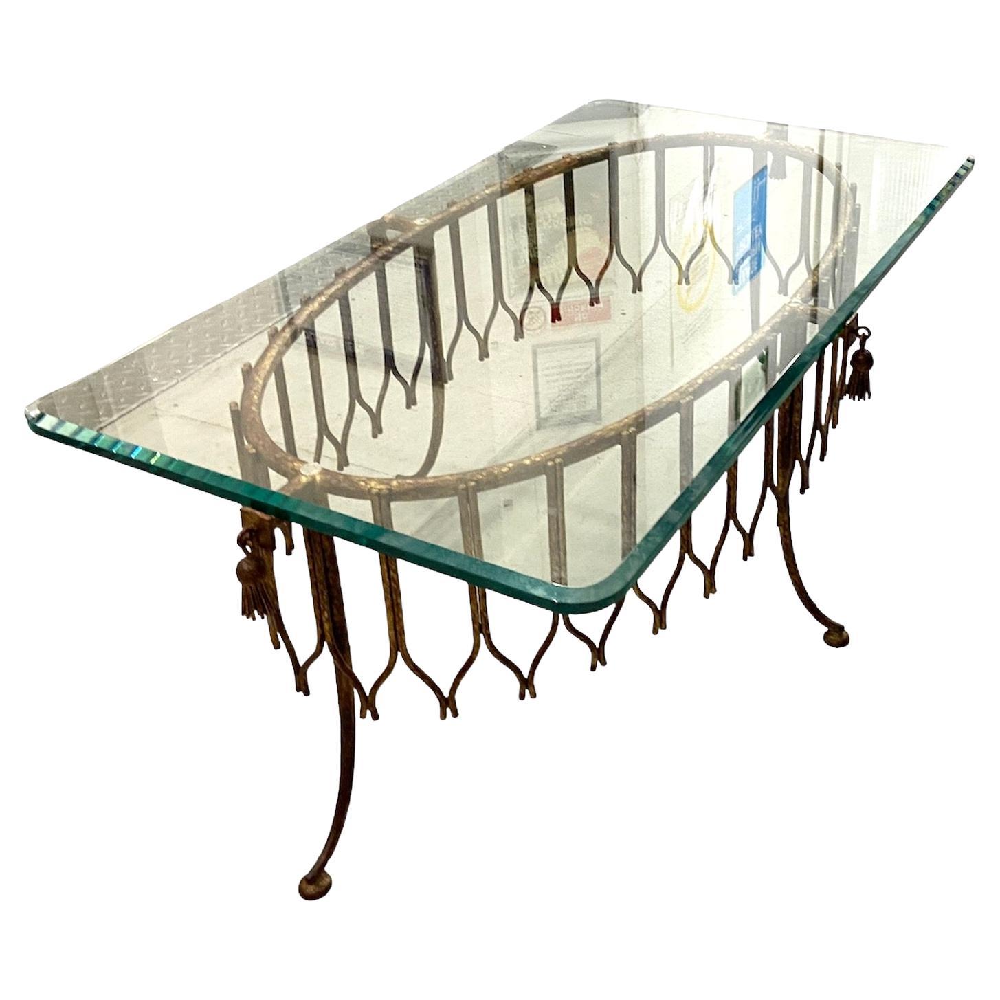 Singular mesa de centro francesa de metal dorado de la década de 1940, con tablero de cristal biselado transparente, grueso y pesado, y borlas de metal dorado. Tiene un diseño y una fabricación preciosos. 

transporte subvencionado