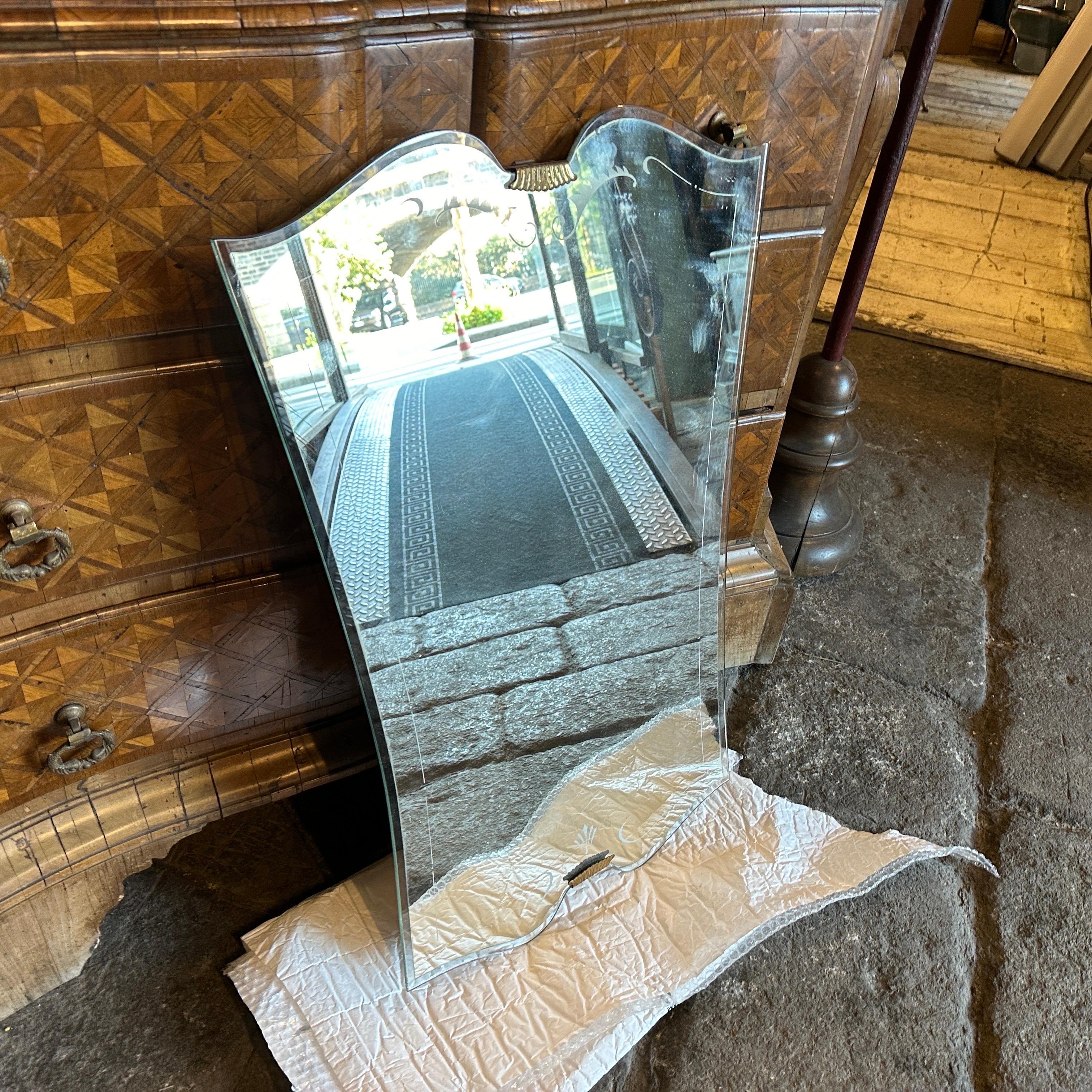 This Italian Wall Mirror exemplifies the opulence, sophistication, and geometric elegance characteristic of the Art Deco movement. It's in original condition with signs of use and age. It features a shield shape, a hallmark of Art Deco design, which