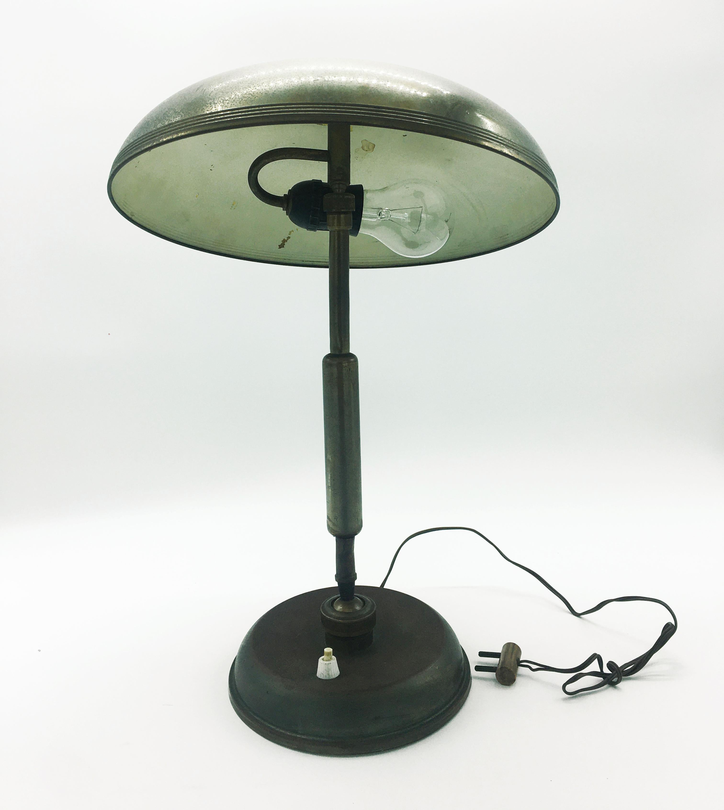 Pre-war Italian brass desk lamp, circa 1940s. A classic desk lamp which combines the characteristics of the Art Deco and Art Nouveau movements. A Lariolux ministeriale rounded shade tops an adjustable brass support stem. The brass features a