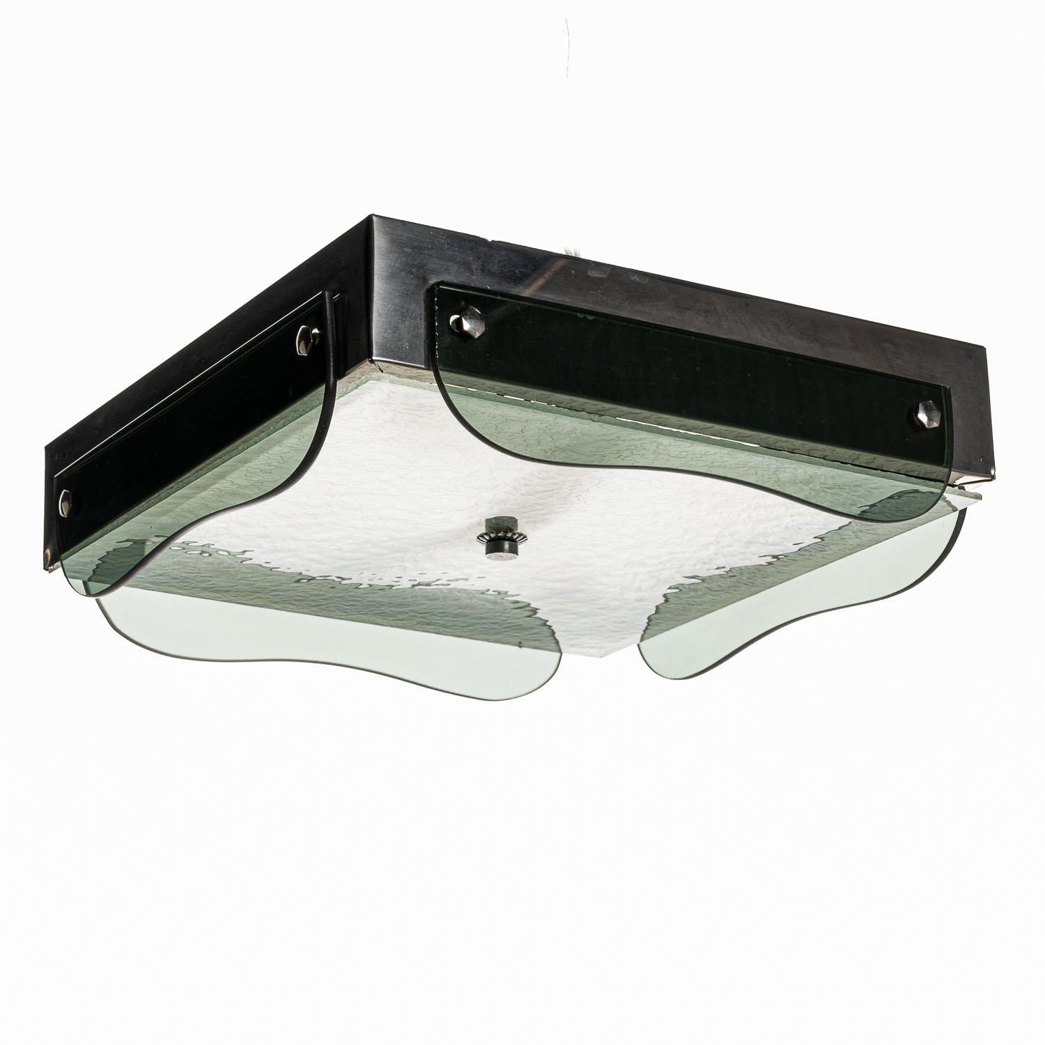 This is a beautiful 1940s flush-mount piece by Veca. The square glass and aluminium construction is in good condition, with the some noticeable markings on the upper aluminium base. The understated design adds a charm to this light.

In full working