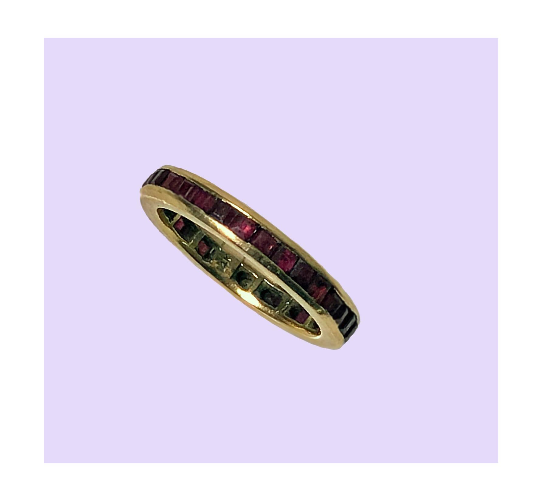 1940's Gold and Ruby channel set Eternity Band. The Ring set with thirty two red square cut rubies, approximately 1.60 ct total ruby weight. Stamped 14K on interior. Total Item Weight: 3.60 grams. Ring Size 7.5.