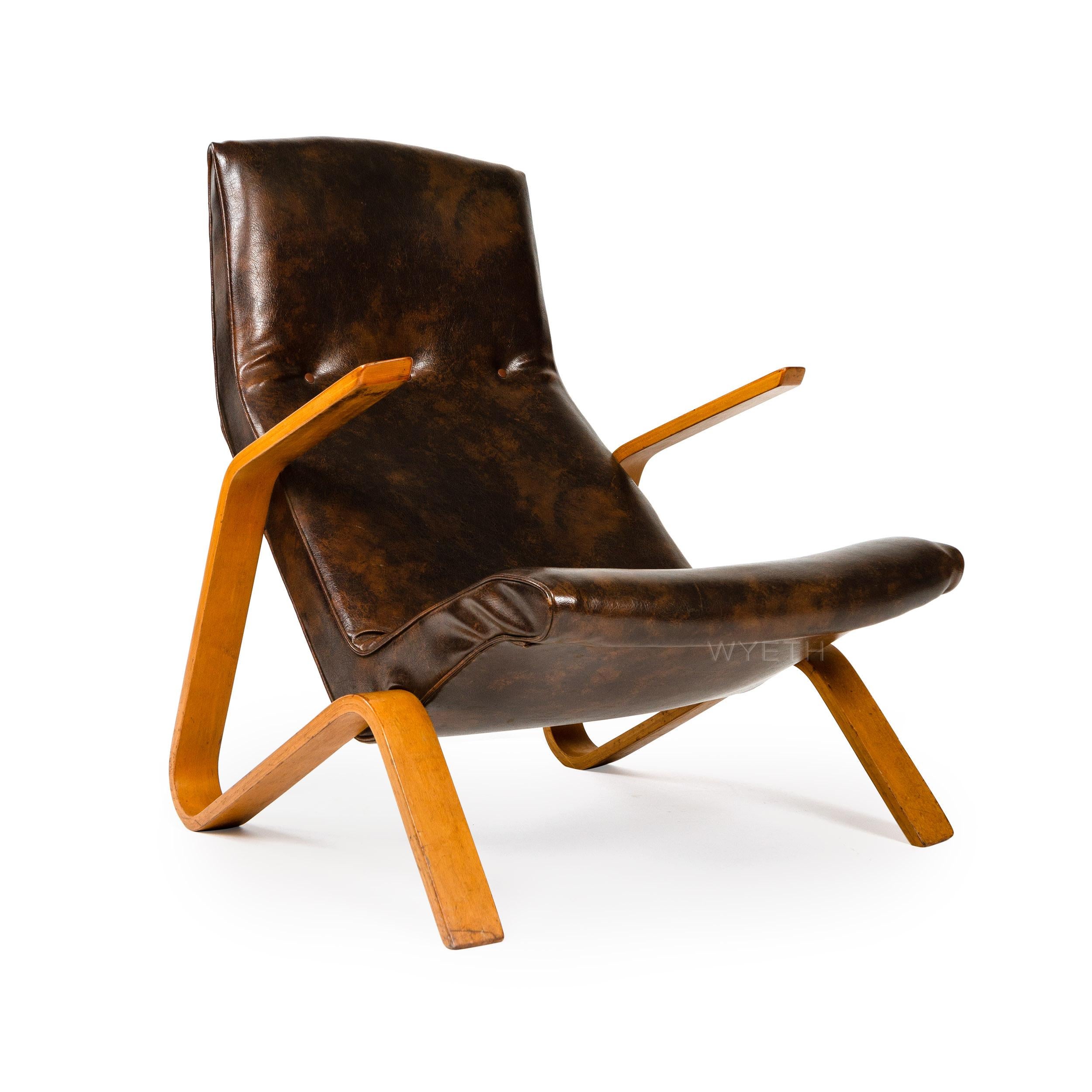 An early lounge chair with original tufted upholstery on a laminated birch bentwood frame. Model 61.