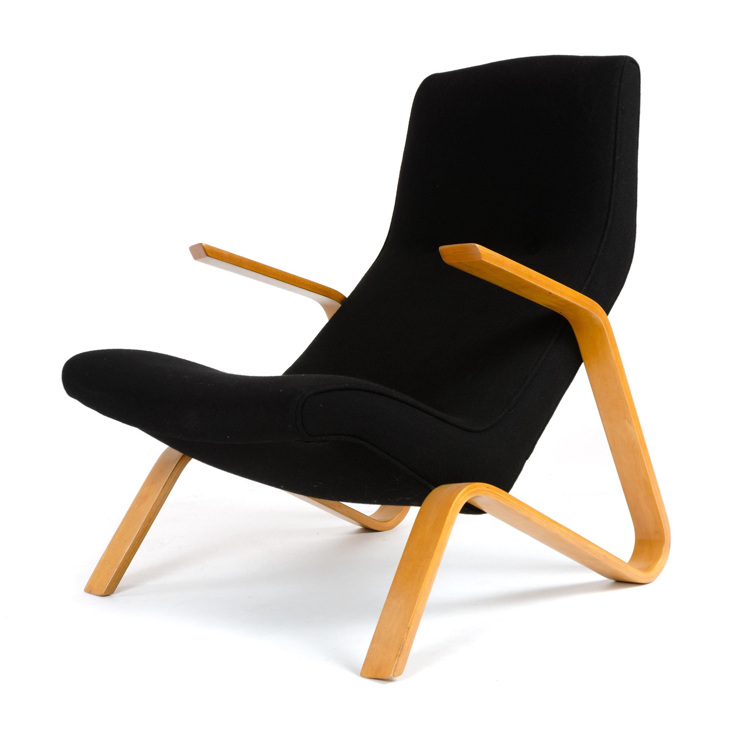An early lounge chair with original tufted upholstery on a laminated birch bentwood frame.