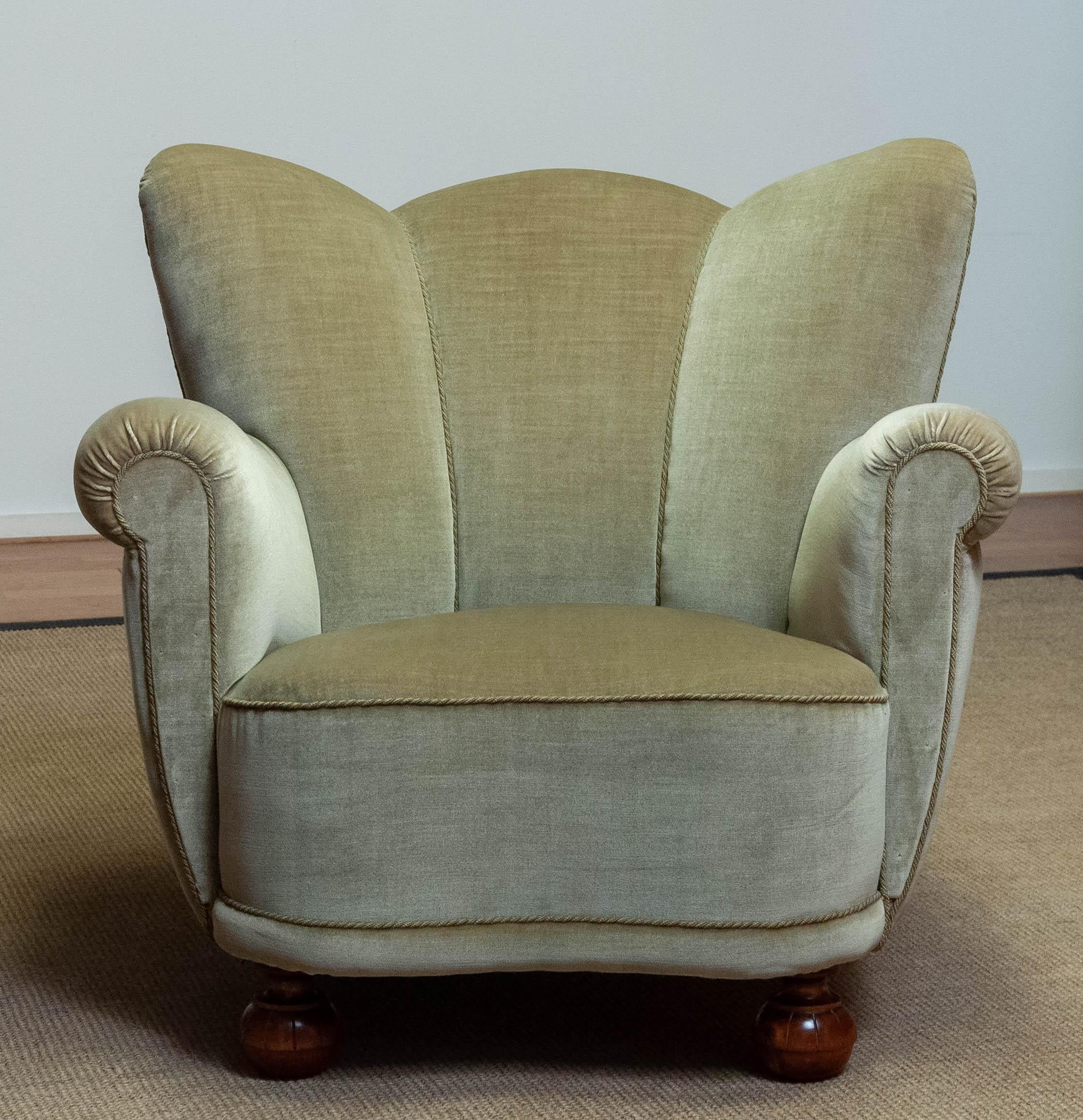 Stunning wingback chair upholstered in the original green velvet in the typical Fritz Hansen style on the 1940s. Hand-tied springs and webbing is replaced and therefor this chair sits and supports great.
Allover in good condition.