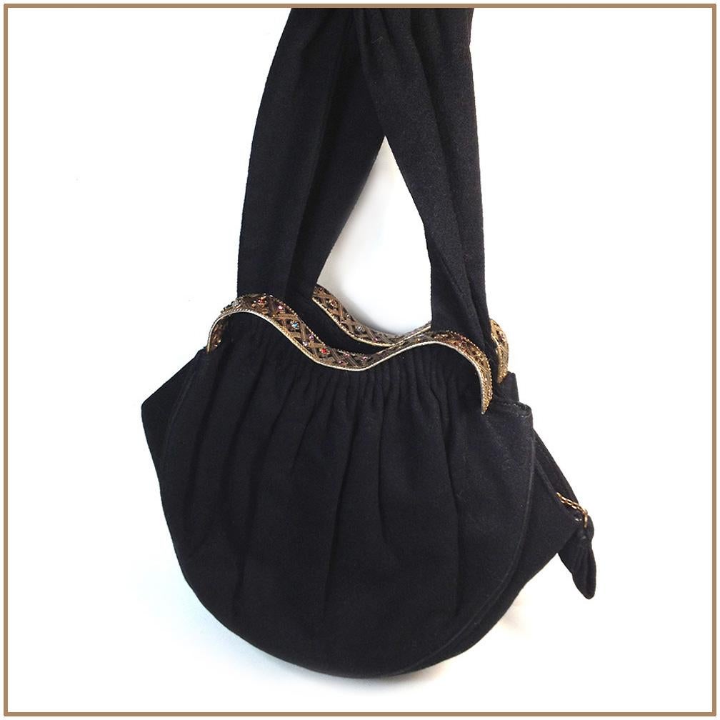 This is a classy 1940s Guild Creations wool hand bag with zip closure. This solid black wool fabirc purse is high lighted with a wave shaped gold-tone metal engraved frame and set with paste stones in small flowers. The bag with its strap totals 16
