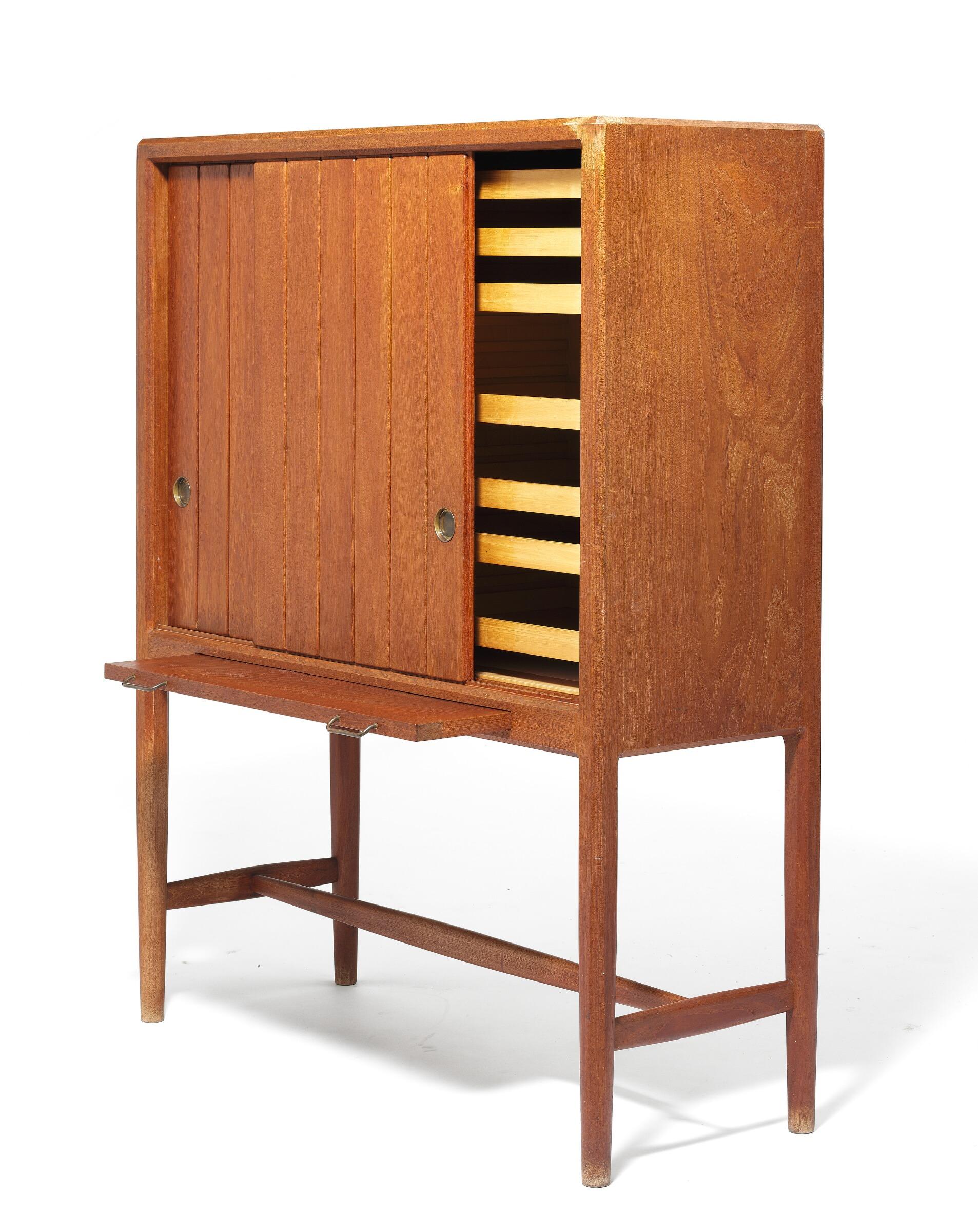 Hans Wegner anni '40 Armadio alto in teak, frontale con due ante scorrevoli e anta estraibile. Ante con motivo intagliato e scanalato in rilievo. Interno in frassino con vassoi e ripiani regolabili. Maniglie in ottone. Progettato nel 1941. Questo