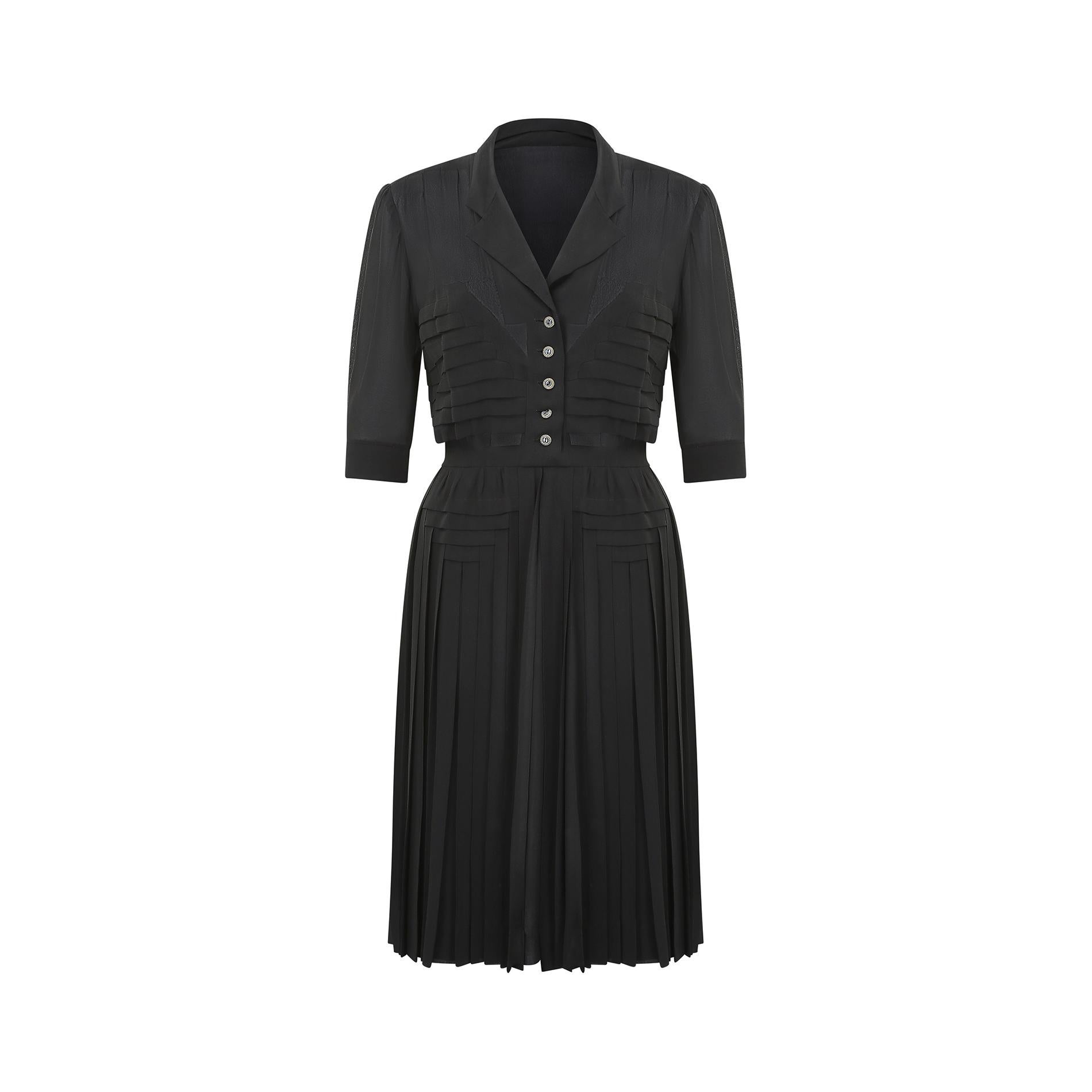 Hervorragendes französisches Haute-Couture-Kleid aus schwarzer Seide, das mit ziemlicher Sicherheit während oder kurz nach dem Zweiten Weltkrieg (1939-1947) hergestellt wurde.  Es hat einen V-Ausschnitt mit dezenter Einkerbung und wird auf der