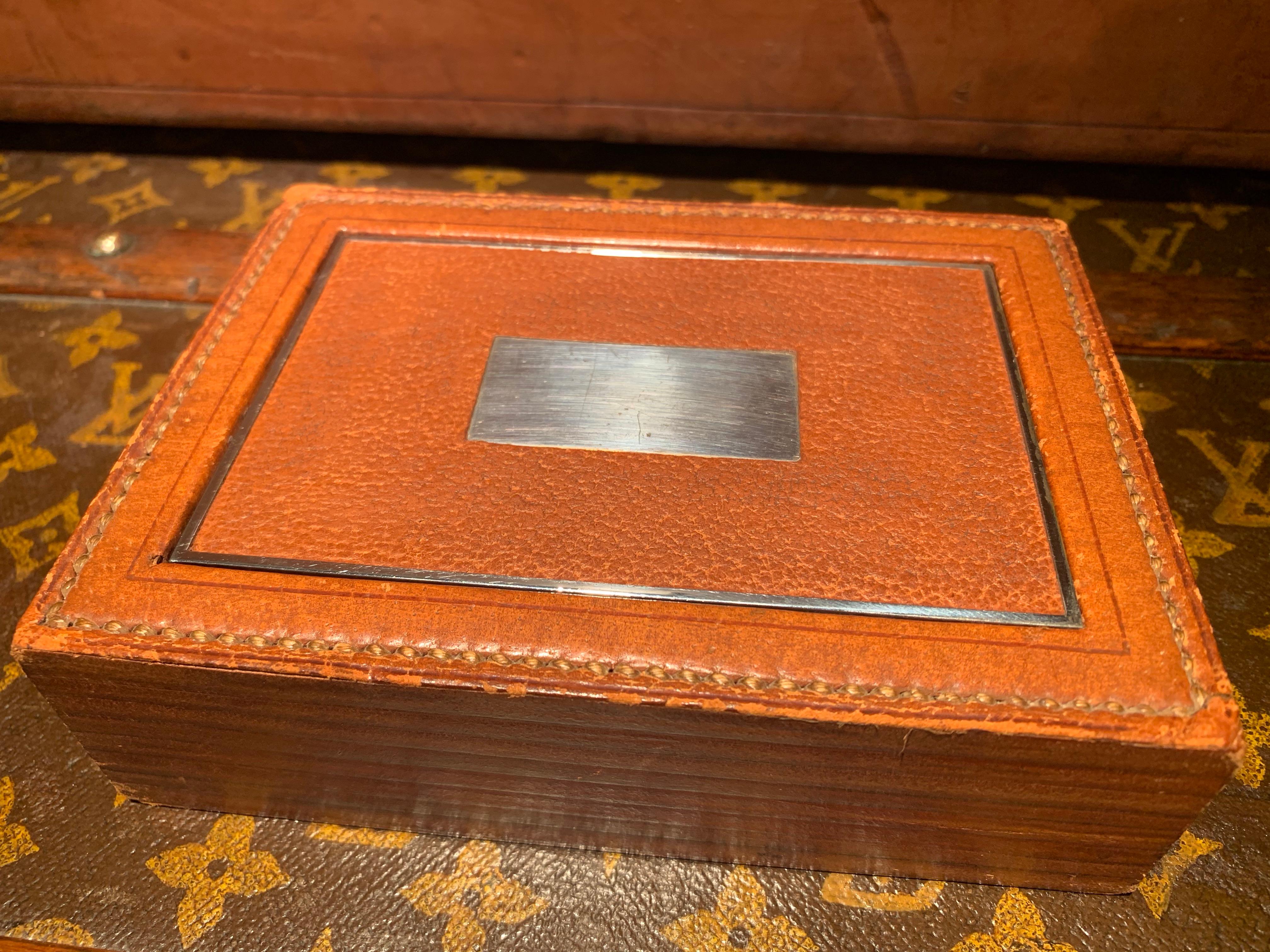 Rare boîte Flip top Hermès des années 1940, conçue par Paul Dupré-Lafon (1900-1971), utilisée pour ranger les cigarettes.

Cuir marron clair avec surpiqûres sellier à l'extérieur et bois acajou à l'intérieur. Le couvercle est en métal chromé