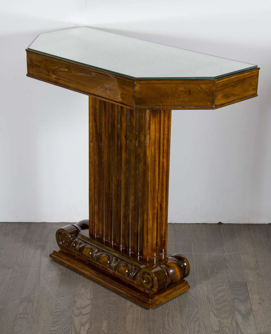 This 1940s Hollywood console was designed by the esteemed American designer Lorin Jackson for Grosfeld House, circa 1945. The console features a column style pedestal base with stylized ionic column and fluted detailed support all in beautiful