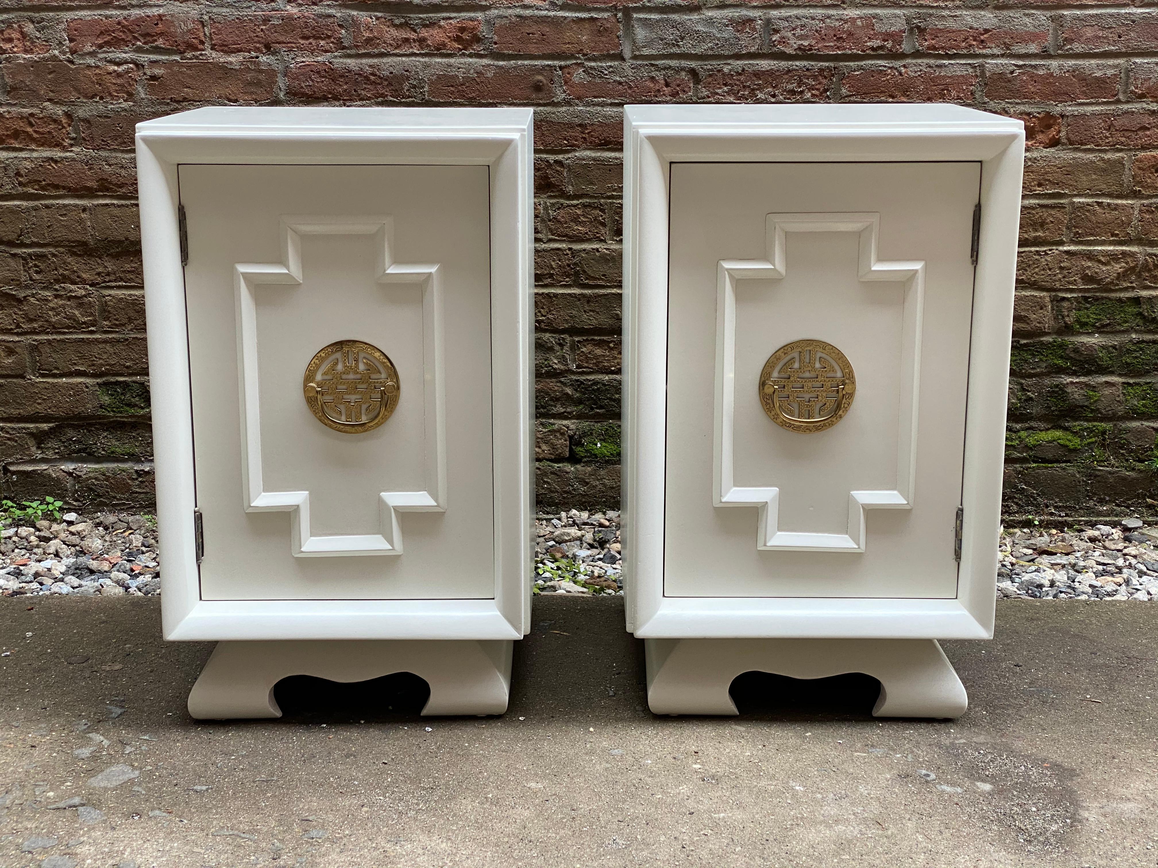 Sweet pair of 1940s Asian inspired custom painted end tables for Big Rapids Furniture Company, New York. Paper White finish with brass hardware. Nicely shaped base with raised rounded moulding. Ample space single shelf interior. Signed on door