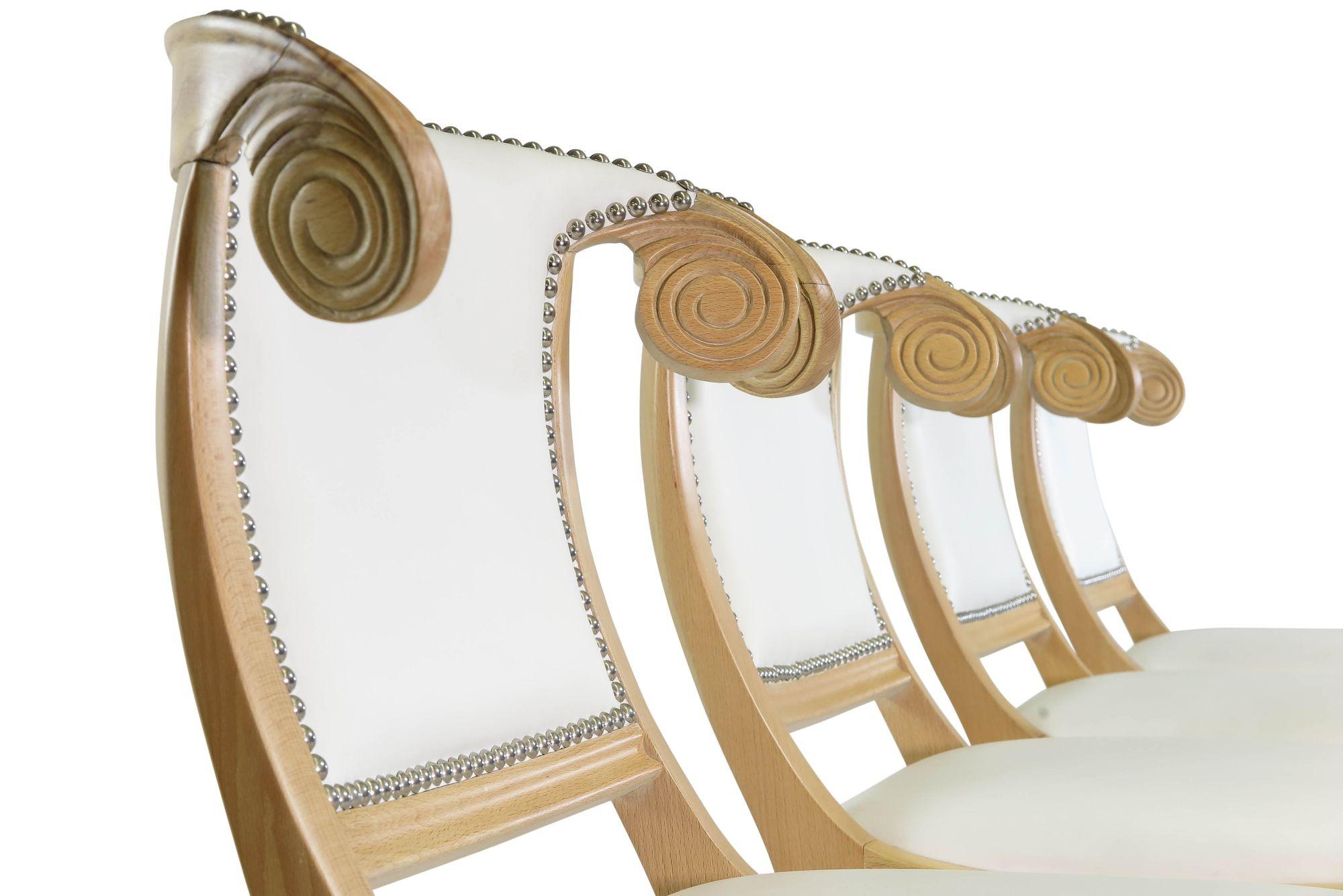 1940's Mid century Hollywood Regency dining chairs crafted of solid beechwood frames with decorative spiral backs and flared sabre legs. The chairs frames are fully restored and upholstered in white leather, trimmed with polished chrome