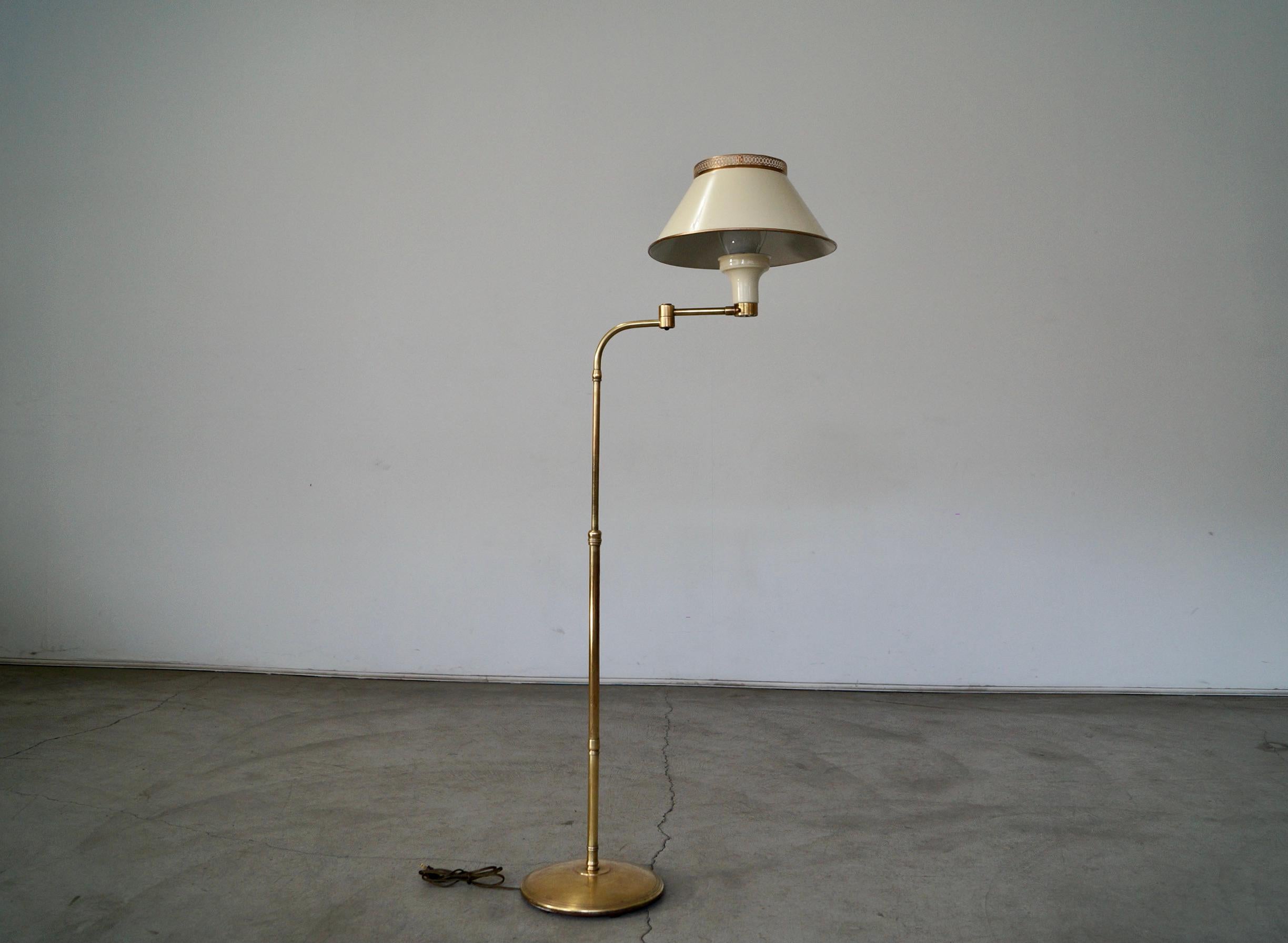 Vintage Mid-century Modern floor lamp for sale. Made of solid brass, and fully restored. This lamp has been re-wired, and the brass has been polished. The shade has been refinished in antique white and gold trims. It’s from the 1940’s, and is a