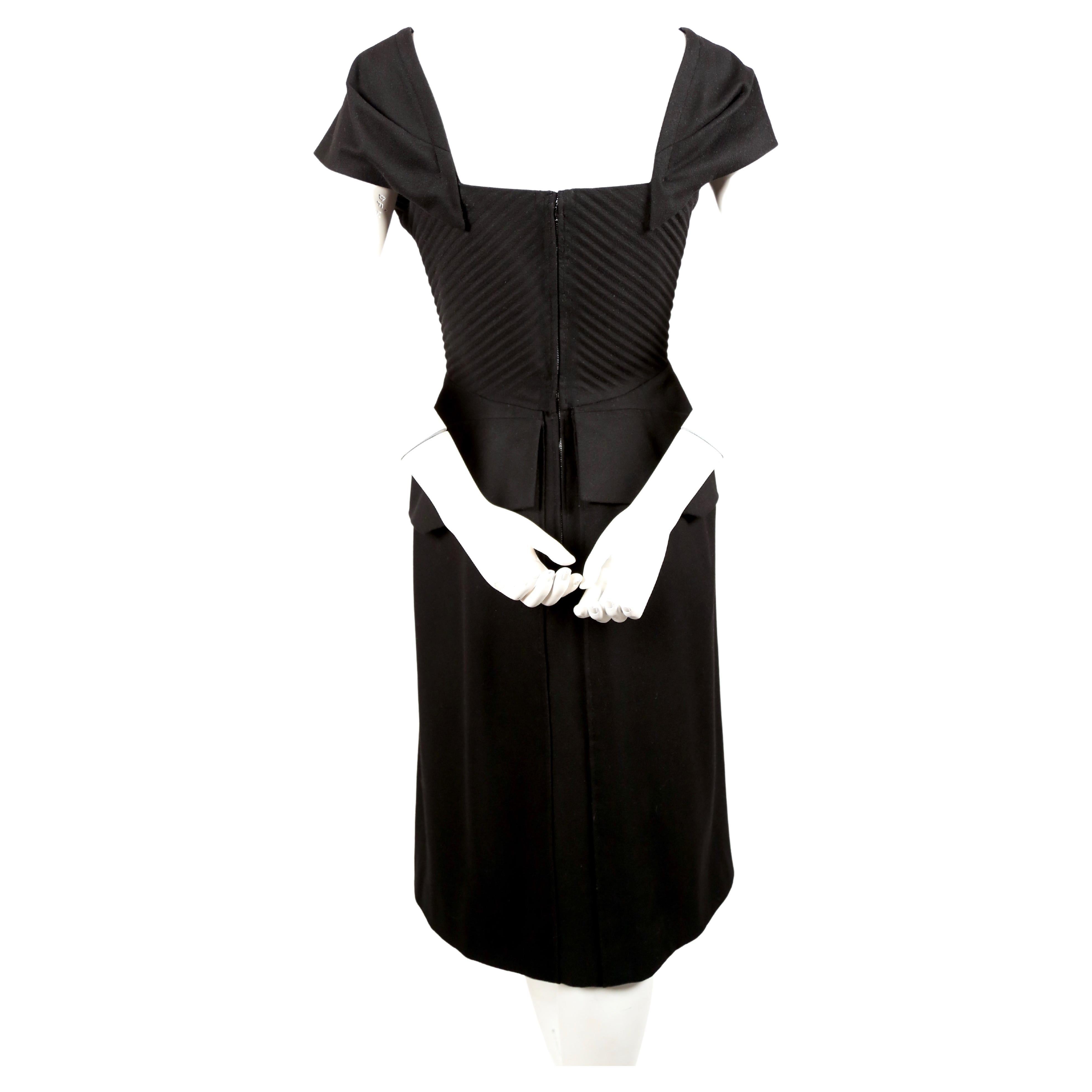Robe haute couture en laine noire de jais avec corsage plissé, épaules embellies et taille péplum, créée par la maison Worth dans les années 1940. Convient le mieux à une taille de 4 à 6. Mesures approximatives : buste 34