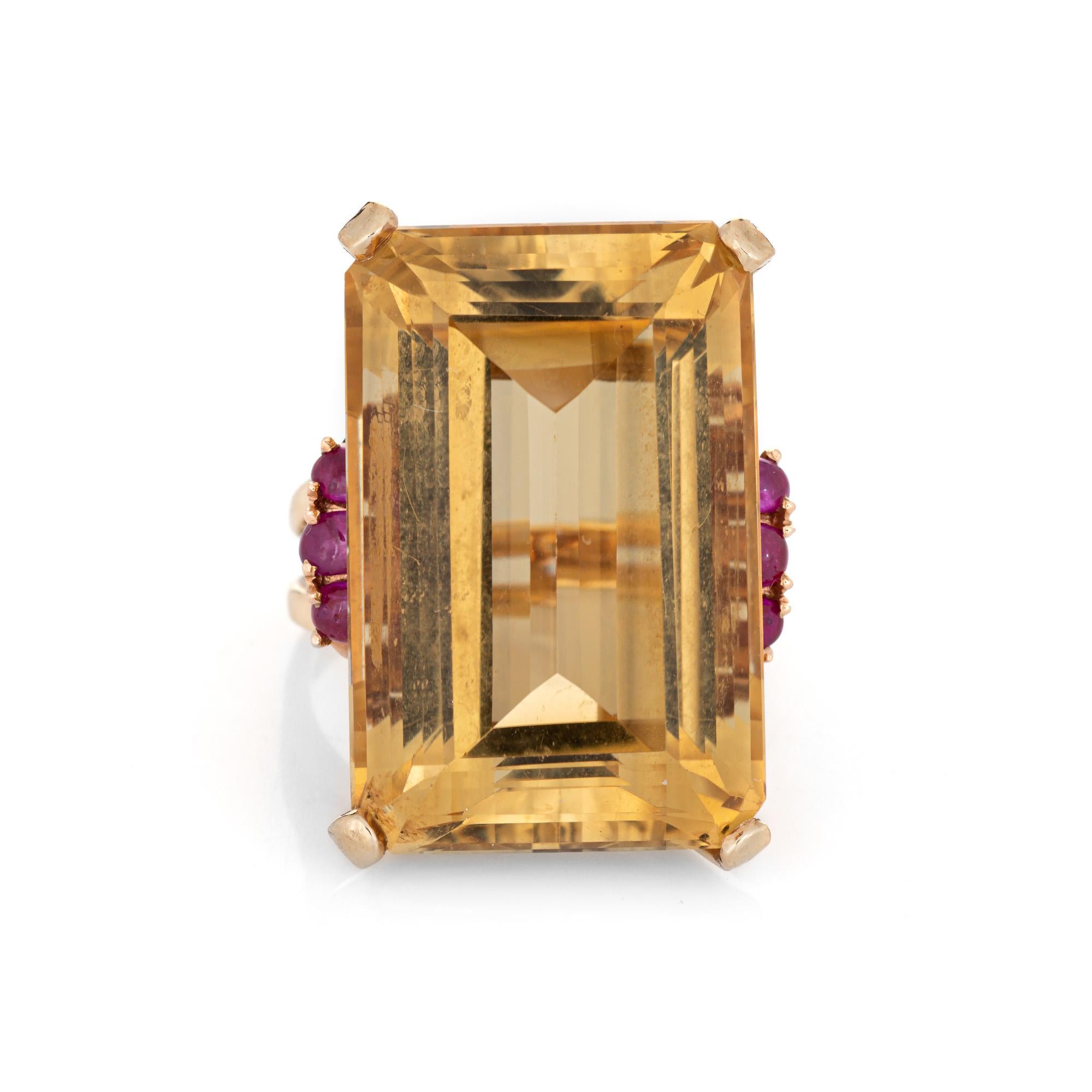 Stylish retro vintage citrine & ruby cocktail ring (circa 1940s) crafted in 14 karat yellow gold. 

Emerald cut citrine measures 29mm x 19mm (estimated at 56.50 carats). Six cabochon cut rubies are estimated at 0.10 carats each (0.60 carats total