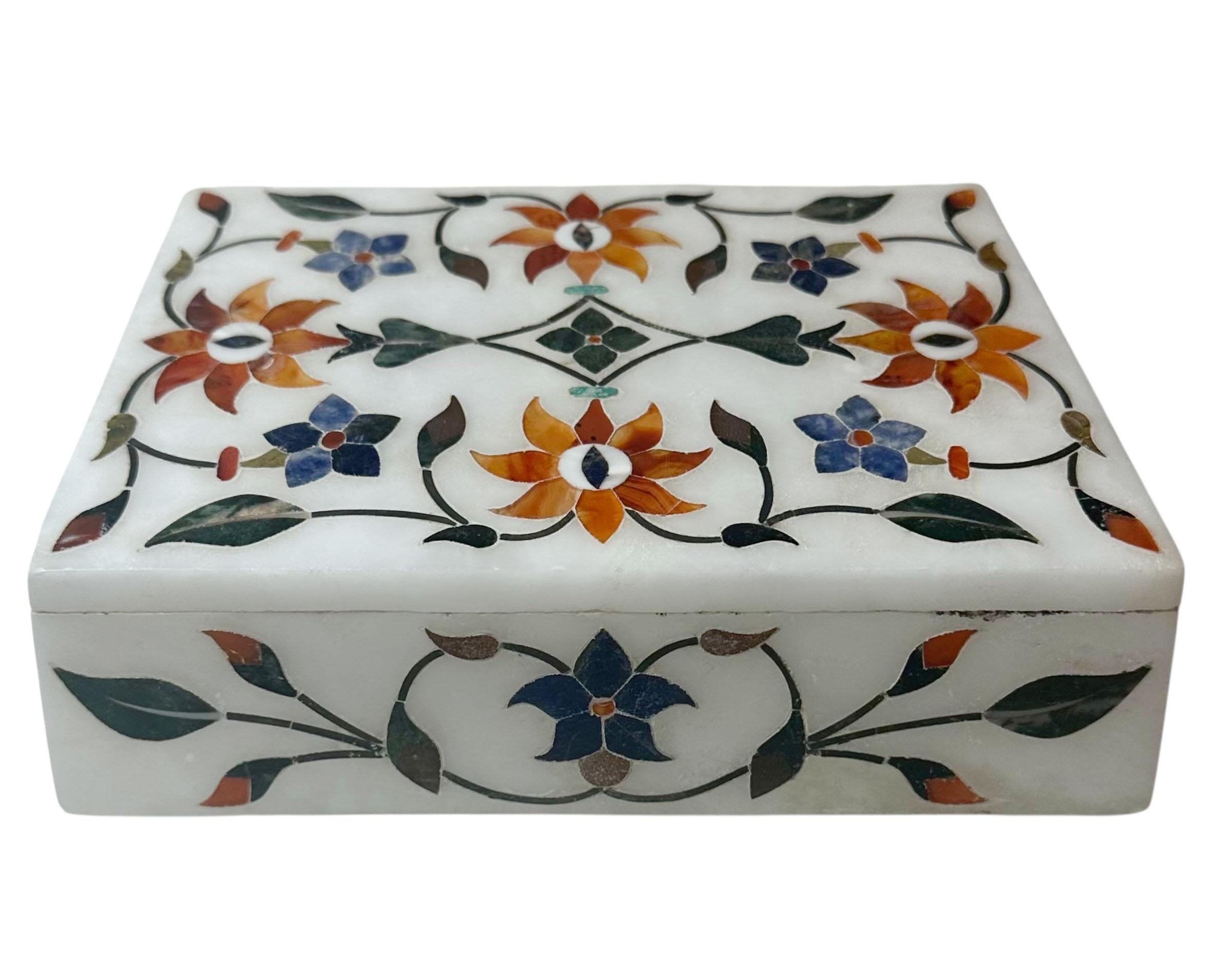A beautiful vintage Indian white marble box, circa 1940s, intricately inlaid with lapis, agate, and other semi-precious stones forming delicate floral vines and flowers across the surface. The craftsmanship reflects the long tradition of Indian