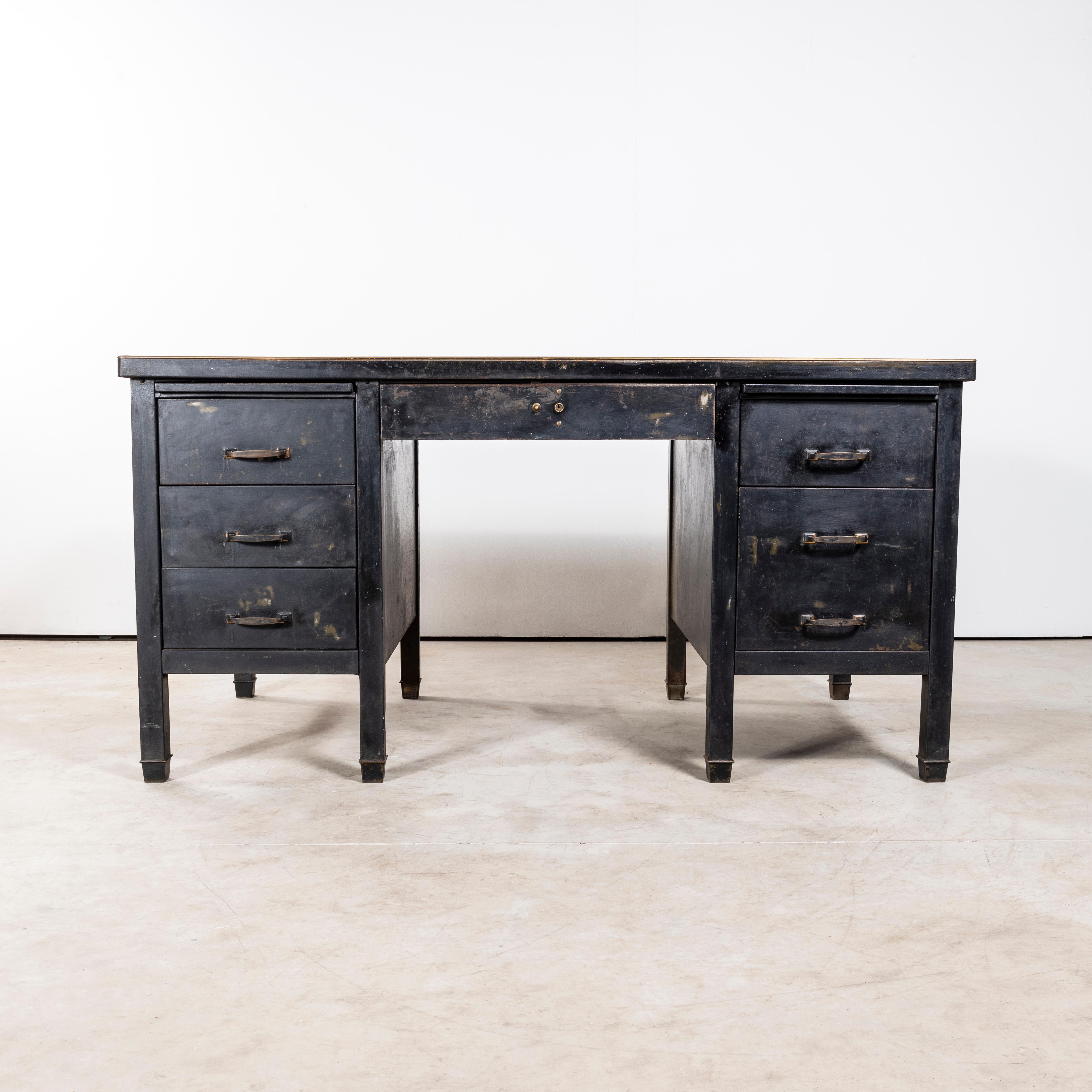 1940's Industrial Metal Desk - Linoleum Top. 

Practical early 1940's metal desk with original brass handles and cupped brass feet detail. Our workshop have replaced the battered original lino with a soft black linoleum top and serviced all the