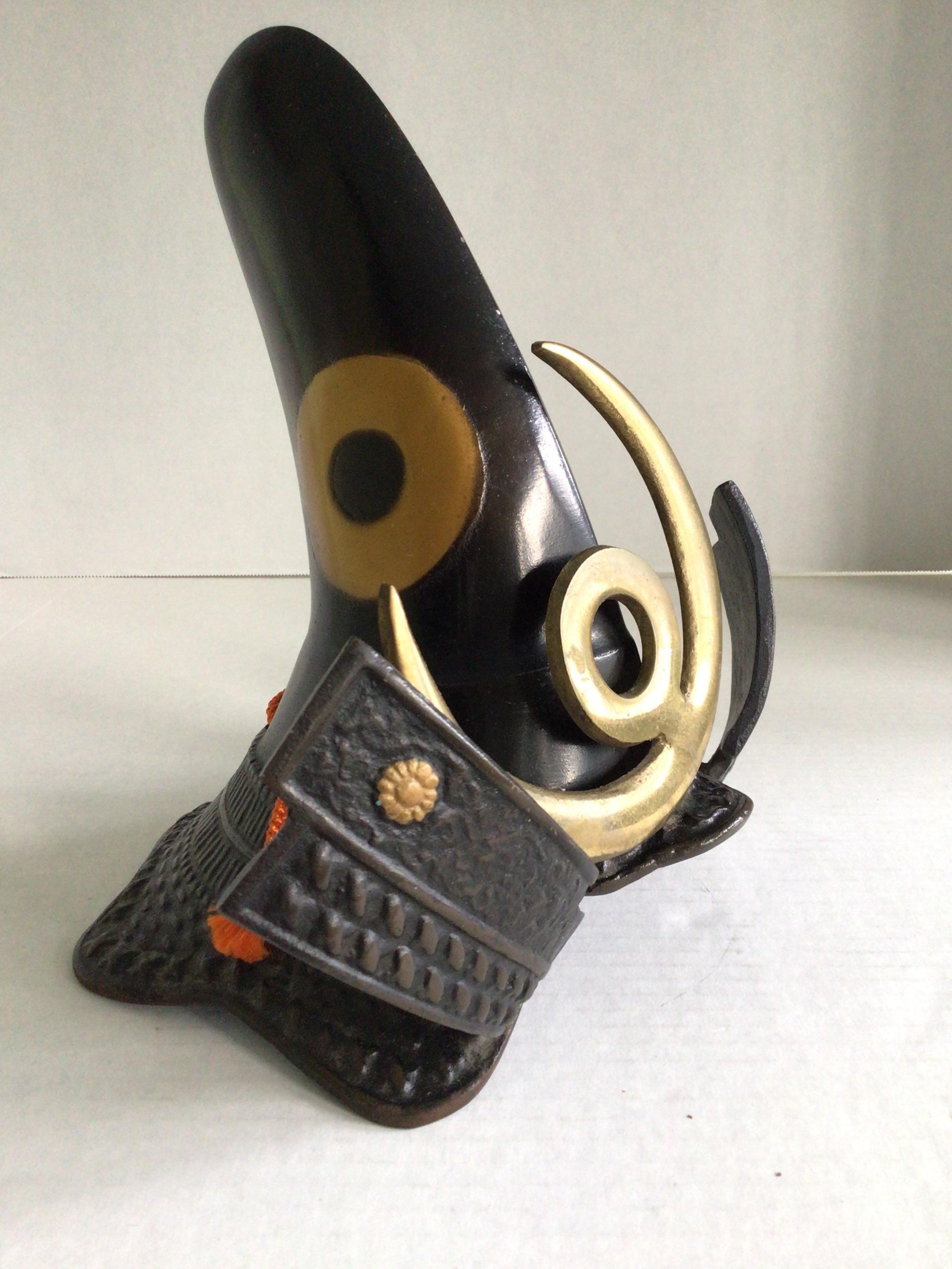 1940s Iron Japanese Samurai Helmet Sculpture from Japan
This is made in the motif of the helmet of a warrior samurai called Kiyomasa Kato
His trademark is a helmet in the shape of a nobleman's hat from the Heian period. 
The golden rings on the