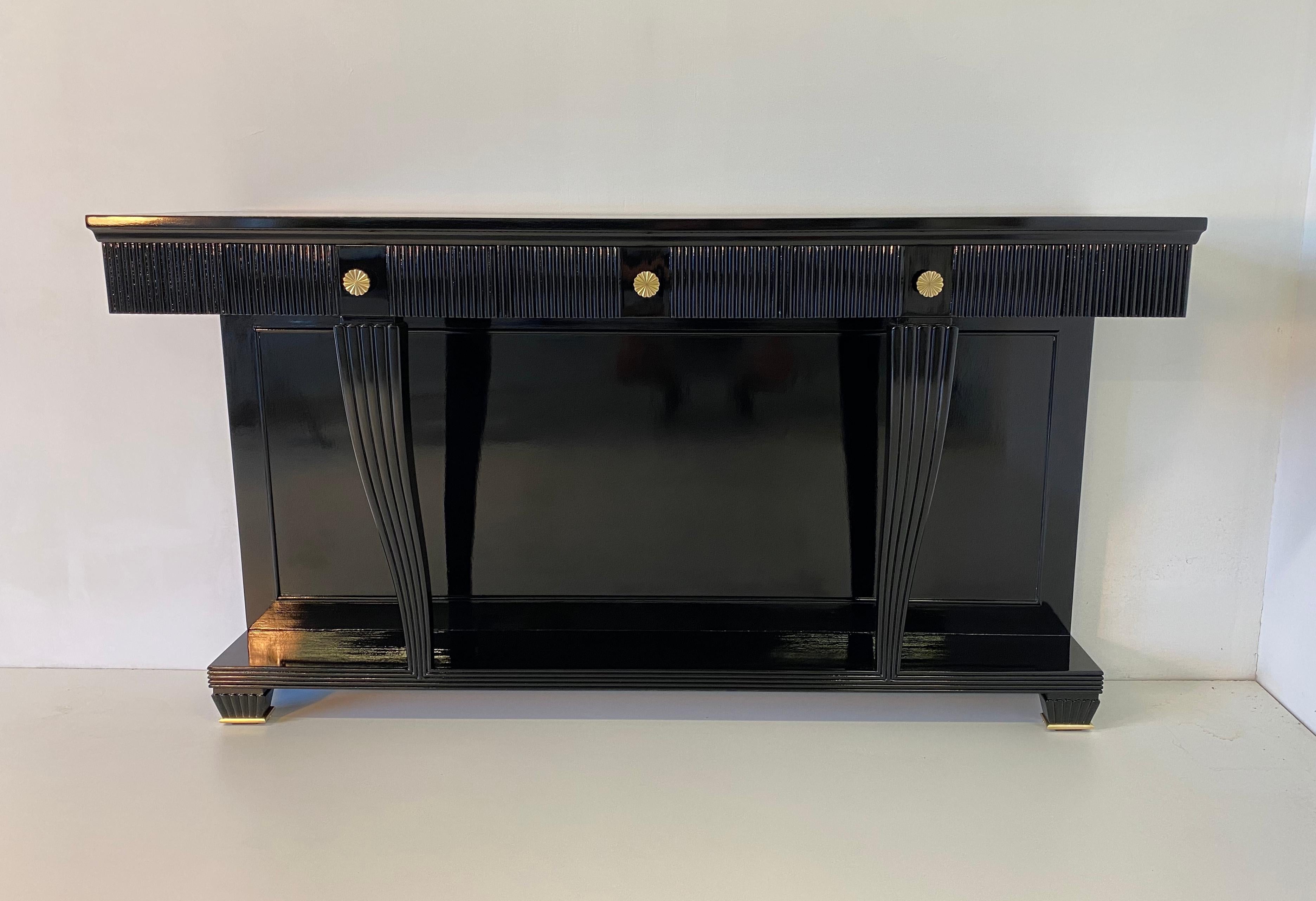 This precious console was produced in Italy in the 1940s and it is completely black lacquered with brass details.
The interiors are in walnut.
The console has the original attachments to be able to fix it to the wall.
Completely restored.