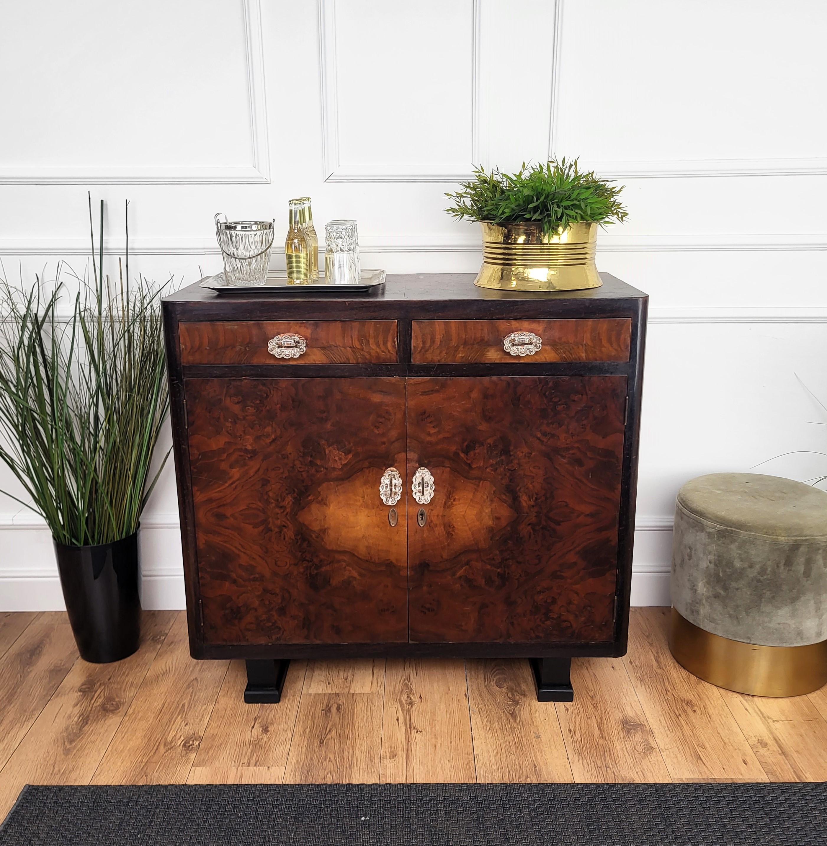 Elegantissima credenza o credenza in stile Art Deco Mid-Century Modern, in bella radica di noce impiallacciata, due cassetti e due ante con ripiani completati da piedi ben intagliati e con belle maniglie. Il design unico e tipico, con la forma