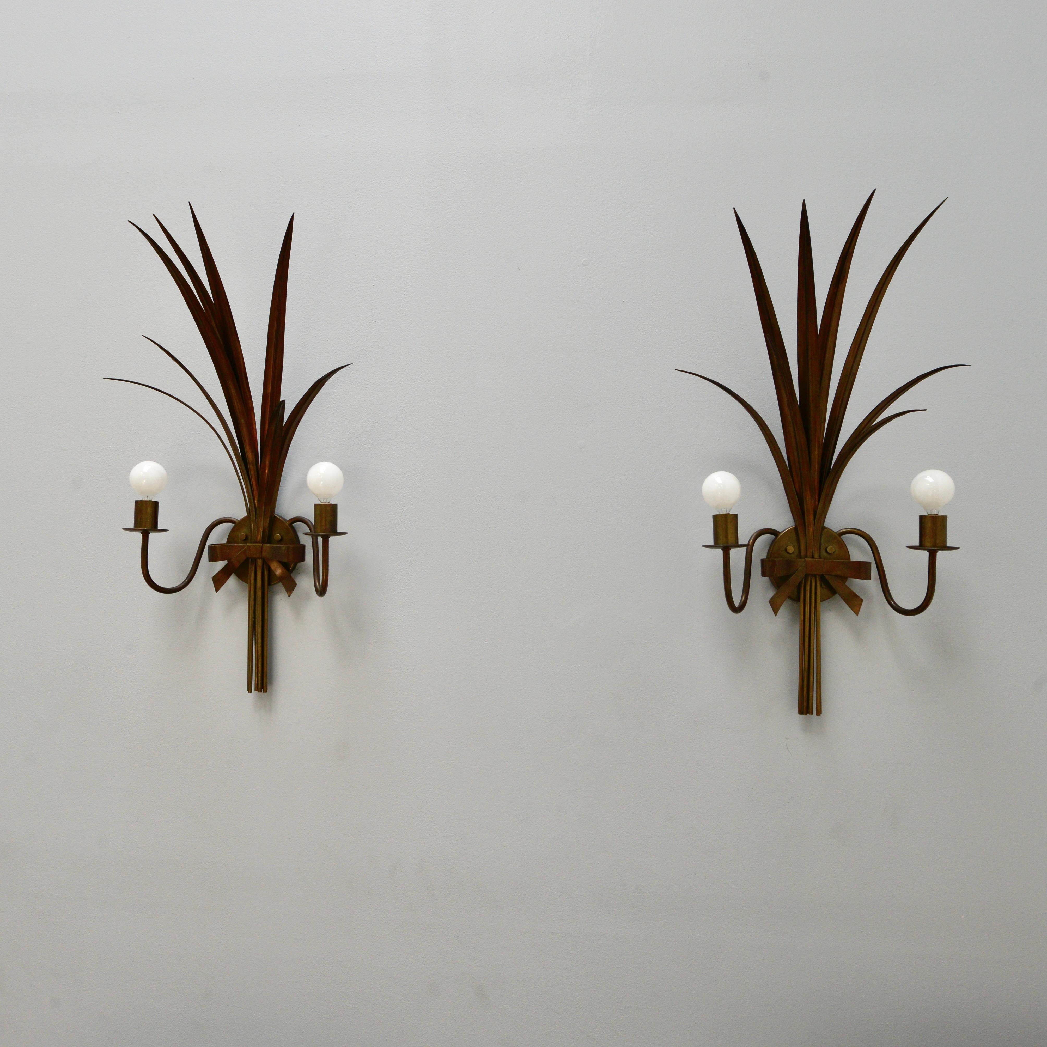 Large pair of brass 1940s botanical sconces. Wonderfully expressive of palm leaves, these sconces are in the original rich patinated brass finish. Partially restored with 2 E14 candelabra based sockets per sconce, for use in the USA. They can also