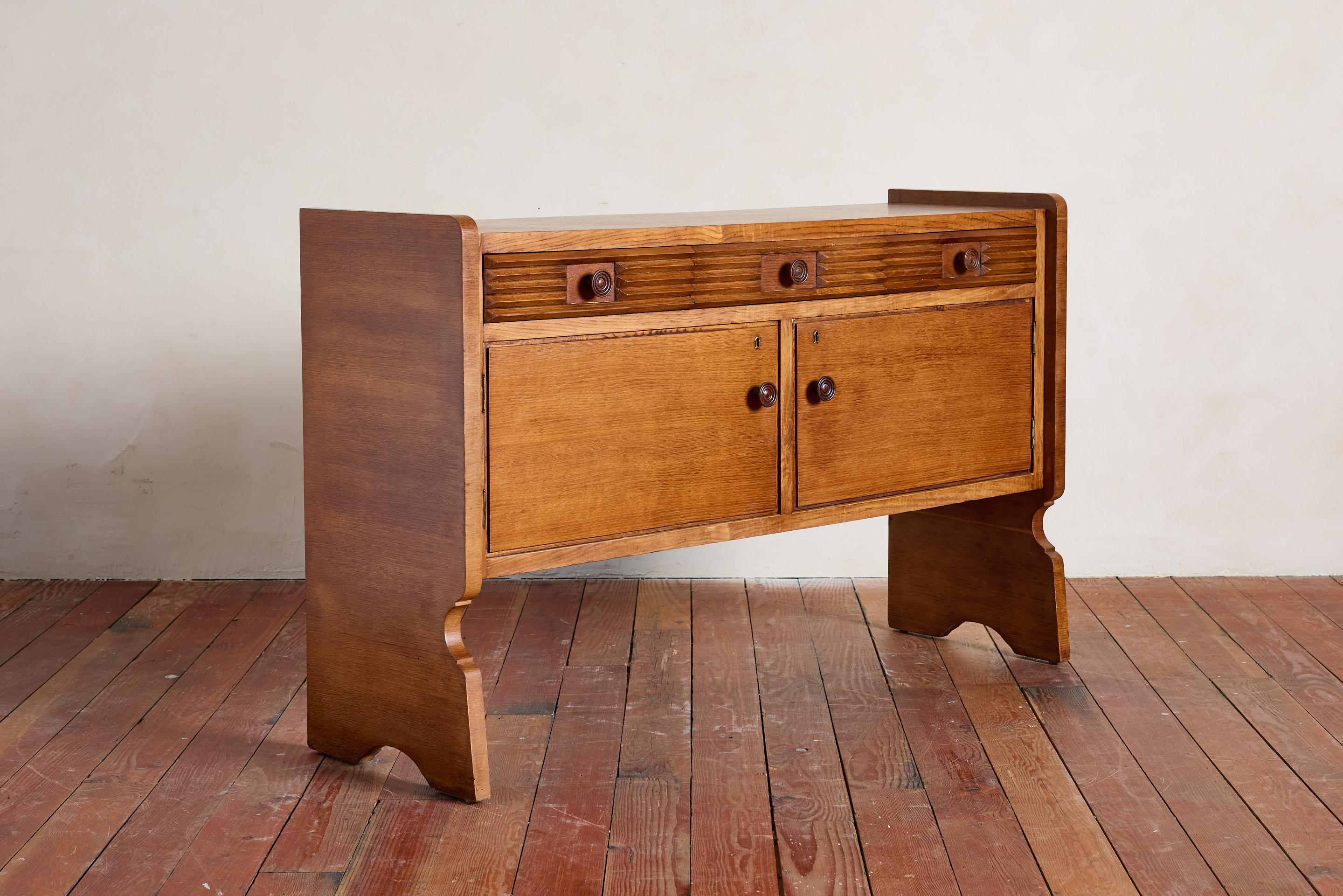 Einzigartiges italienisches Sideboard mit drei geriffelten Schubladen mit geschnitzten runden Knöpfen. 

Der Schrank hat 2 Türen, die sich zur Aufbewahrung öffnen lassen. 

Wunderbare Patina / Großer Maßstab 

Ein Schlüssel inklusive.

Italien,