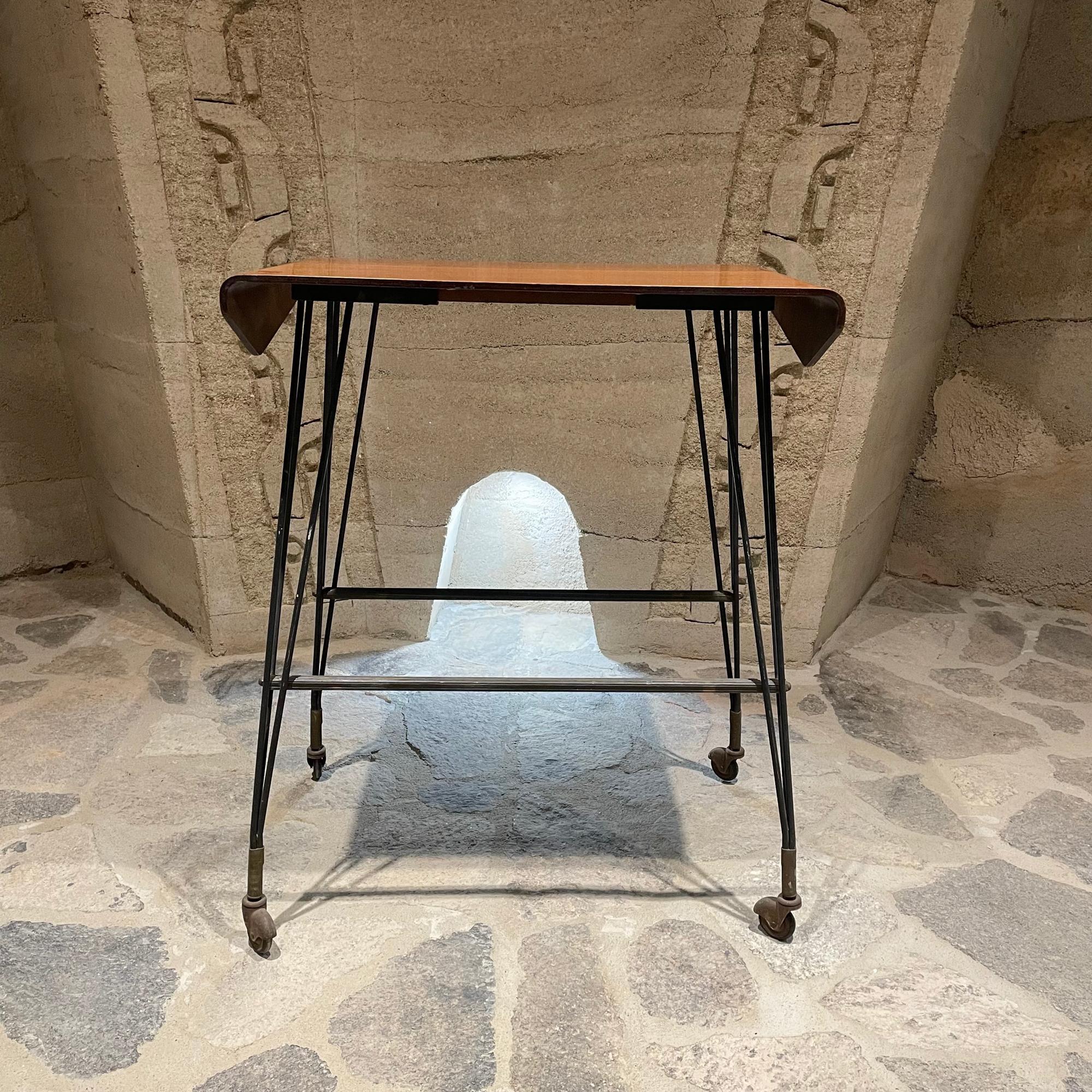 1940s Italian Carrello TV Table on vintage casters 
Side table crafted in bent plywood + walnut veneer.
Original lacquer finish. Sturdy iron legs.
Unmarked.
H 32 in. x W 26 in. x D 16.5 in.
Original unrestored vintage preowned condition. 
Vintage