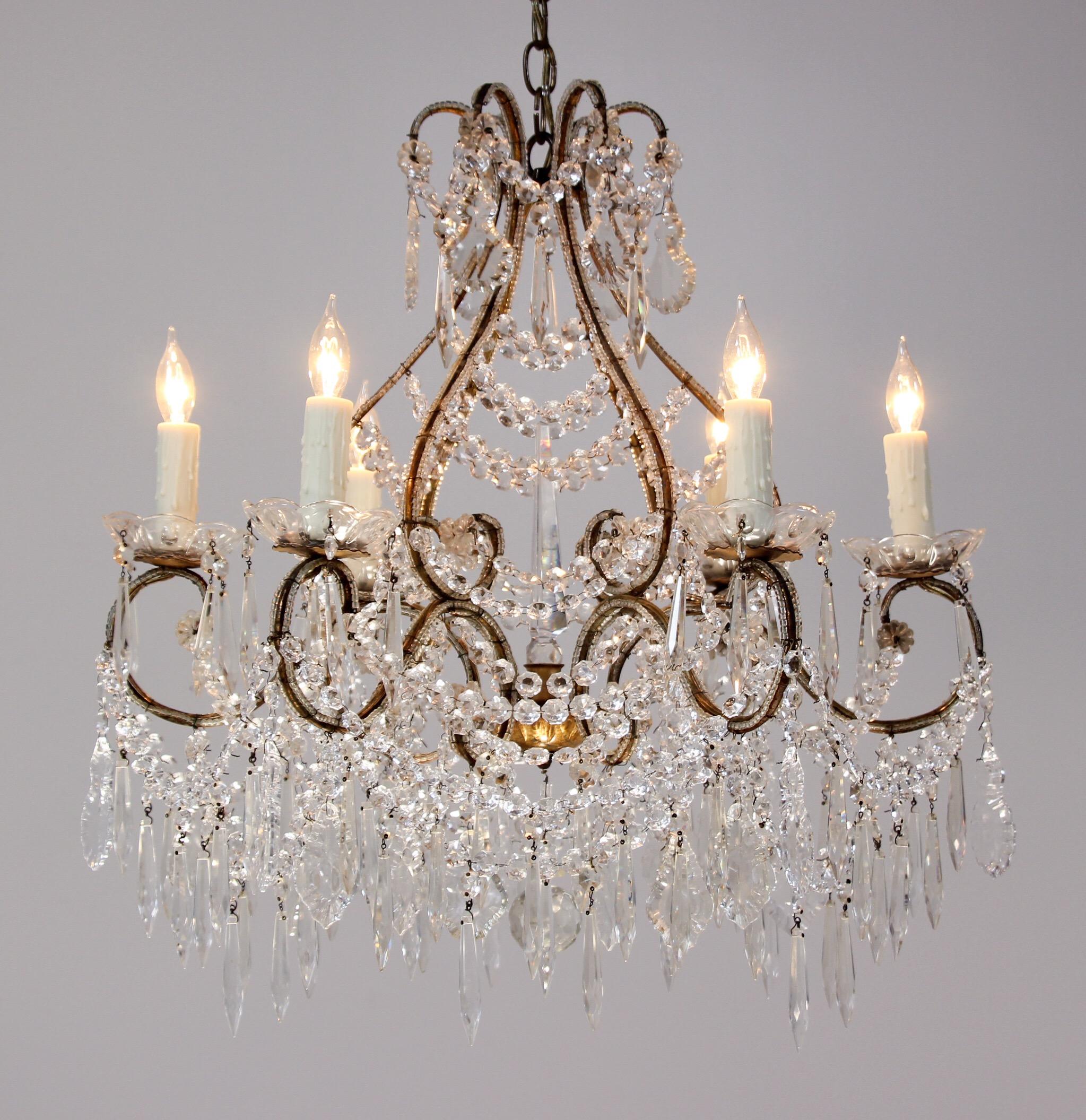 Glamorous, Italian 1940s crystal chandelier featuring a graceful gilt-iron beaded frame festooned with a bounty of polished crystal beads and prisms. The gilt finish has acquired a pleasing warm patina over the decades.  
     
Perfect for a space