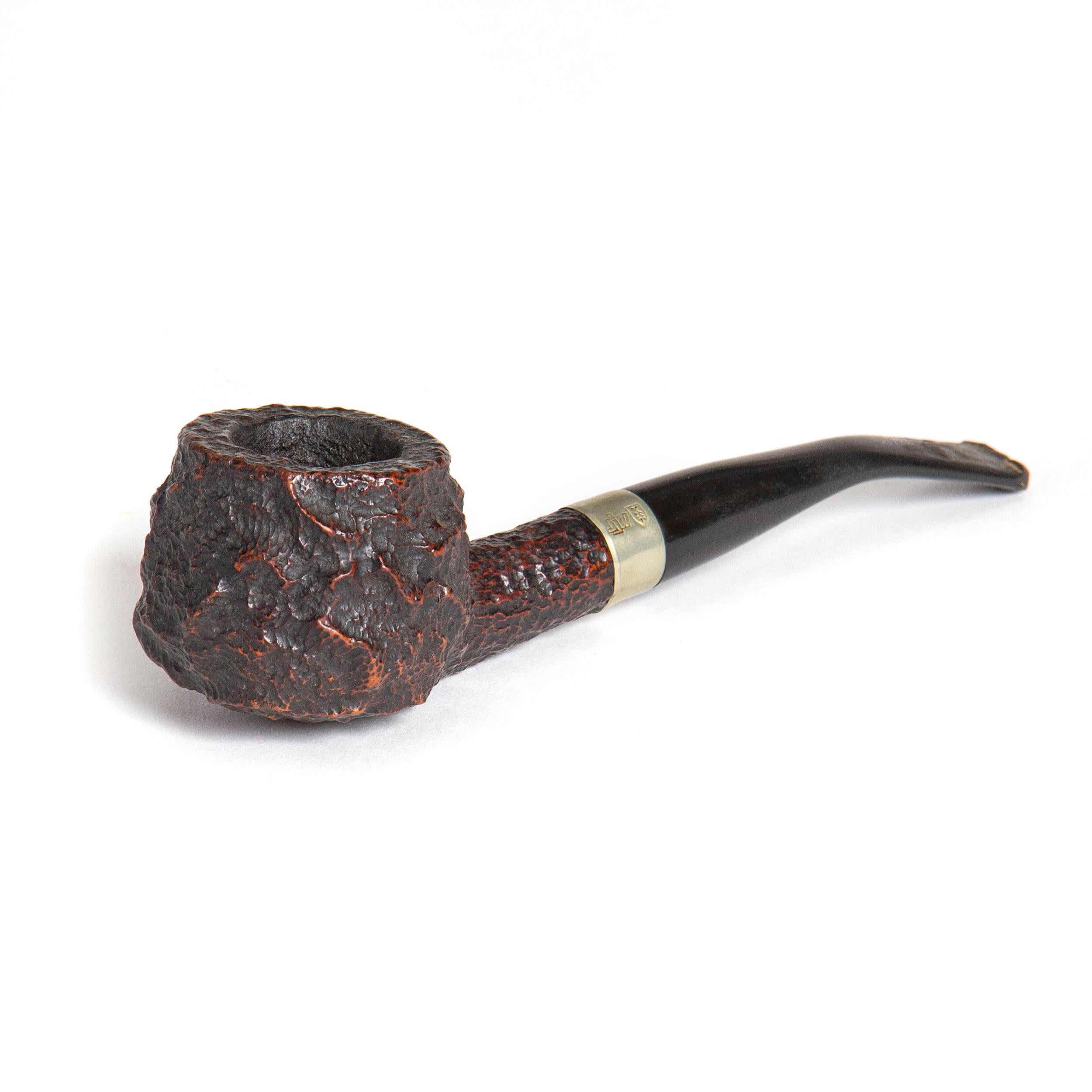 A hand carved wood smoking pipe, the handle circled by a silver band with etched decoration. Marked 