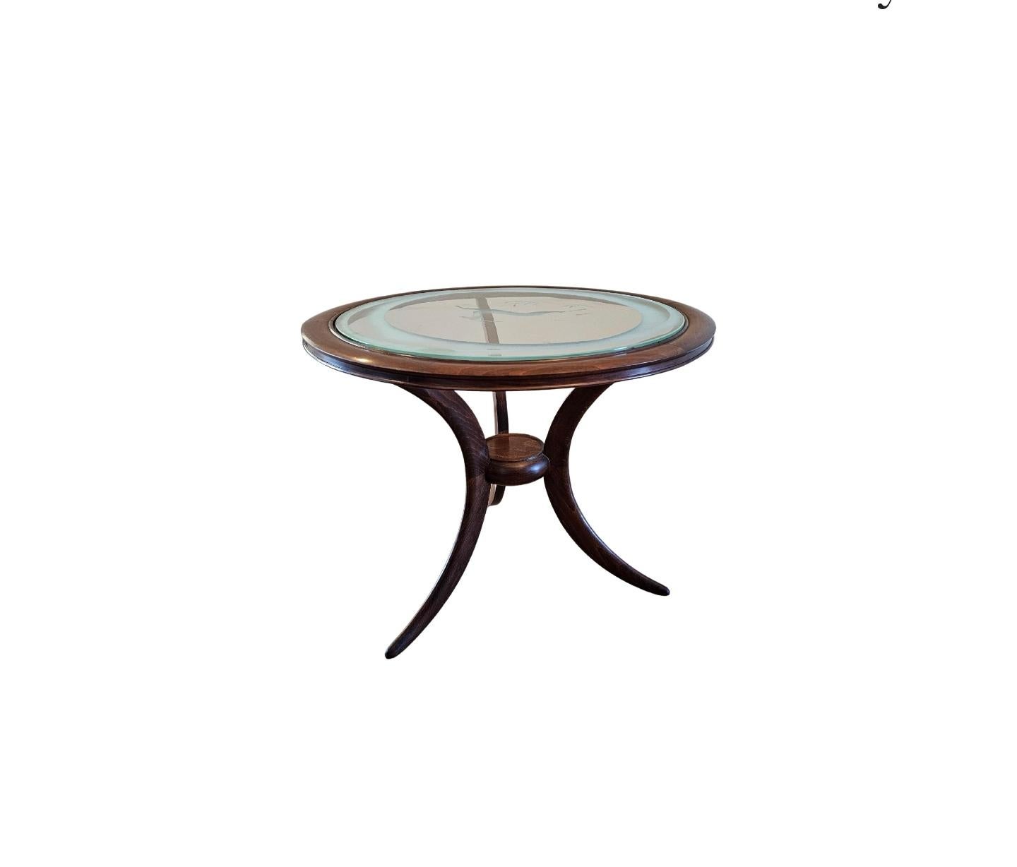 A vintage Italian mid-century modern round occasional table.

Italy, circa 1940s, in the manner of legendary Italian modernist architect and designer Ico Parisi, two-tier, featuring a inset circular glass top with etched leaping impala design,