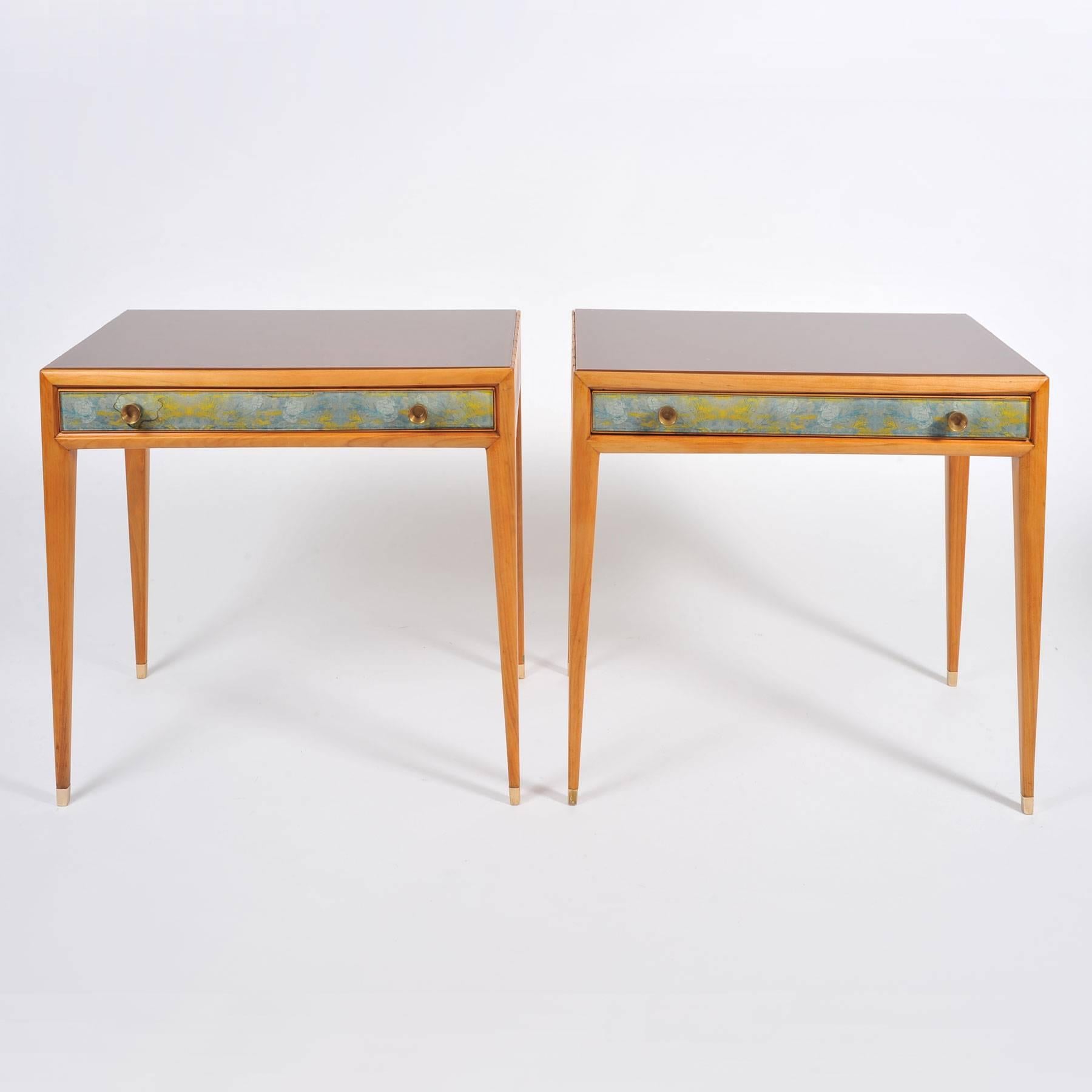 Elegant and rare nightstands/bedsides fronted with reverse-painted abstract designs in soft blues greens and gold by Osvaldo Borsani and Adriano Spilimbergo. Each drawer has two original circular brass handles. Rich pear wood with warm amber