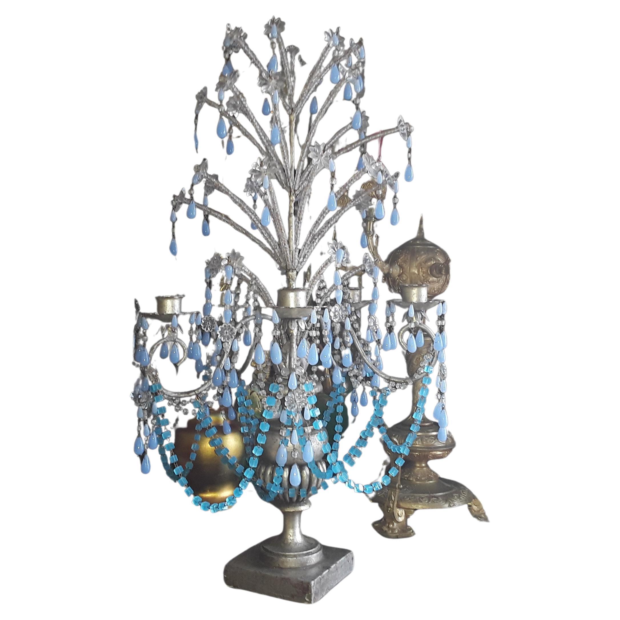 Vase en bois sculpté argenté de style Hollywood Regency des années 1940 avec des gerbes d'étoiles en cristal et des chaînes et détails en verre d'art opalin bleu - Candelabra/ Girandole/ Lampe de table à bougie. Il s'agit d'une grande lampe à bougie