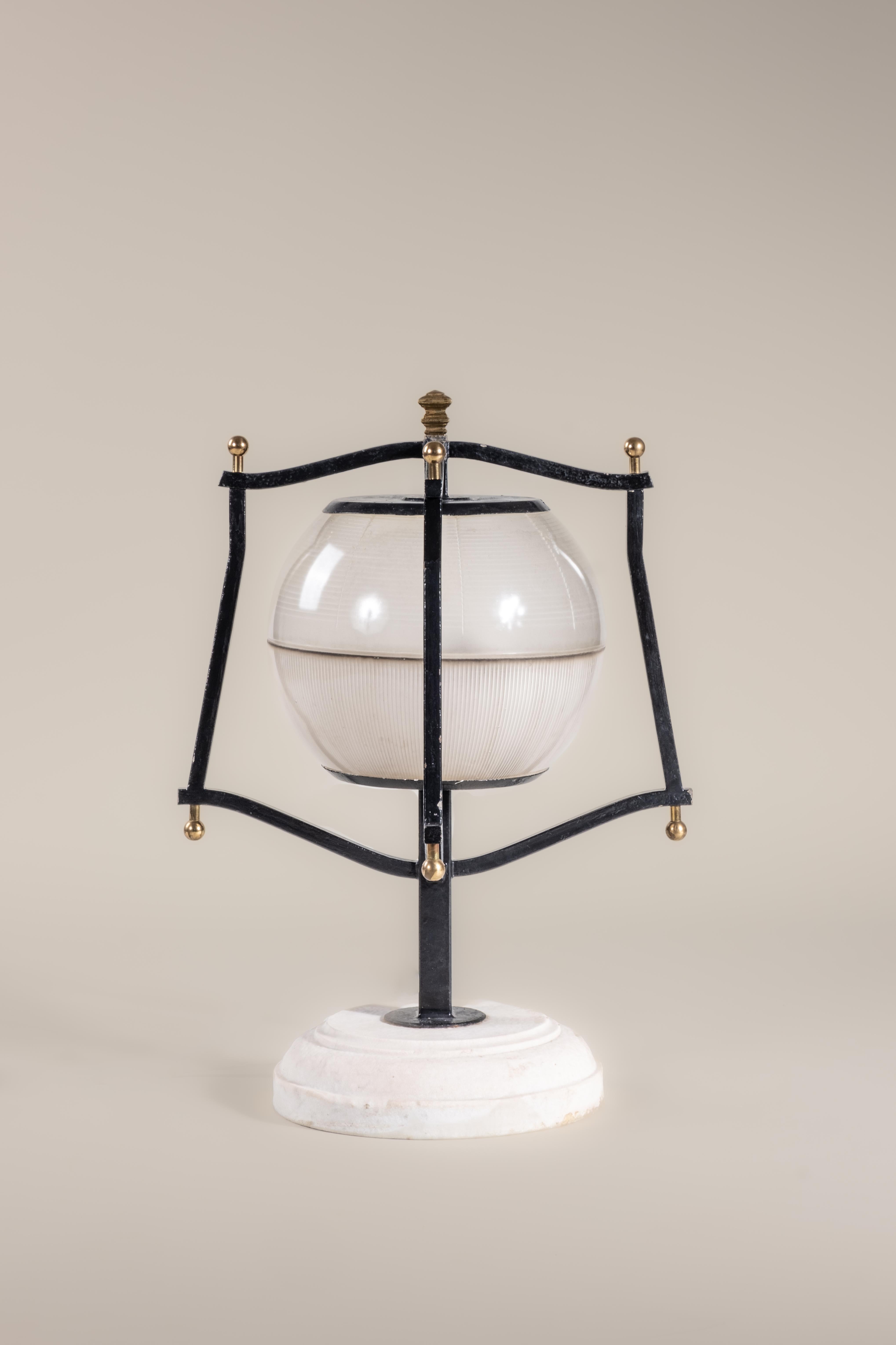 This 1940s table lamp features a lantern-style cage made of painted metal, with spherical brass finials. A satin opal glass globe encases the bulb. Made in Italy. Condition consistent with age and use. Newly rewired.

Materials: metal base, opal