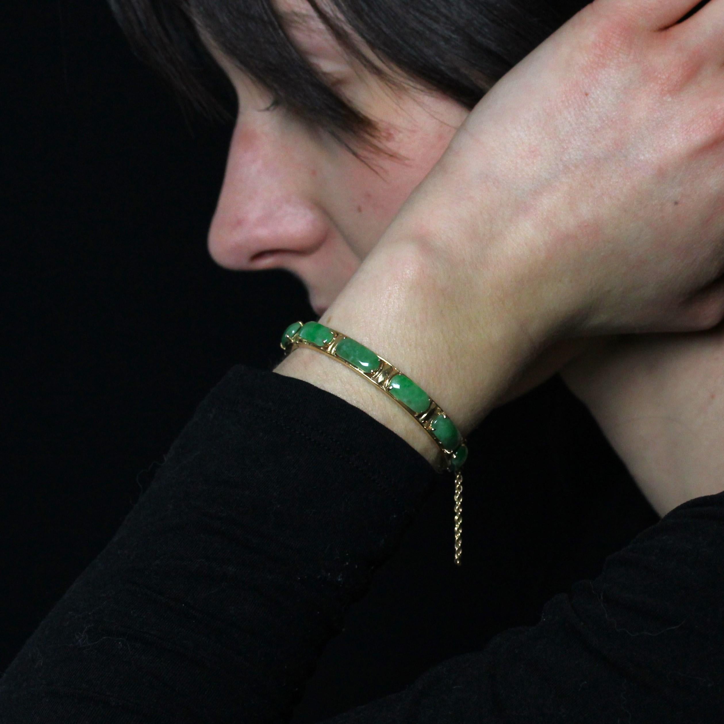 Bracelet en or jaune 18 carats.
Ce bracelet rond est idéal pour un enfant ou un poignet très fin. Le sommet est orné de 10 jades rectangulaires taillés en cabochon et retenus par des griffes. Le fermoir est un fermoir à cliquet avec une chaîne de