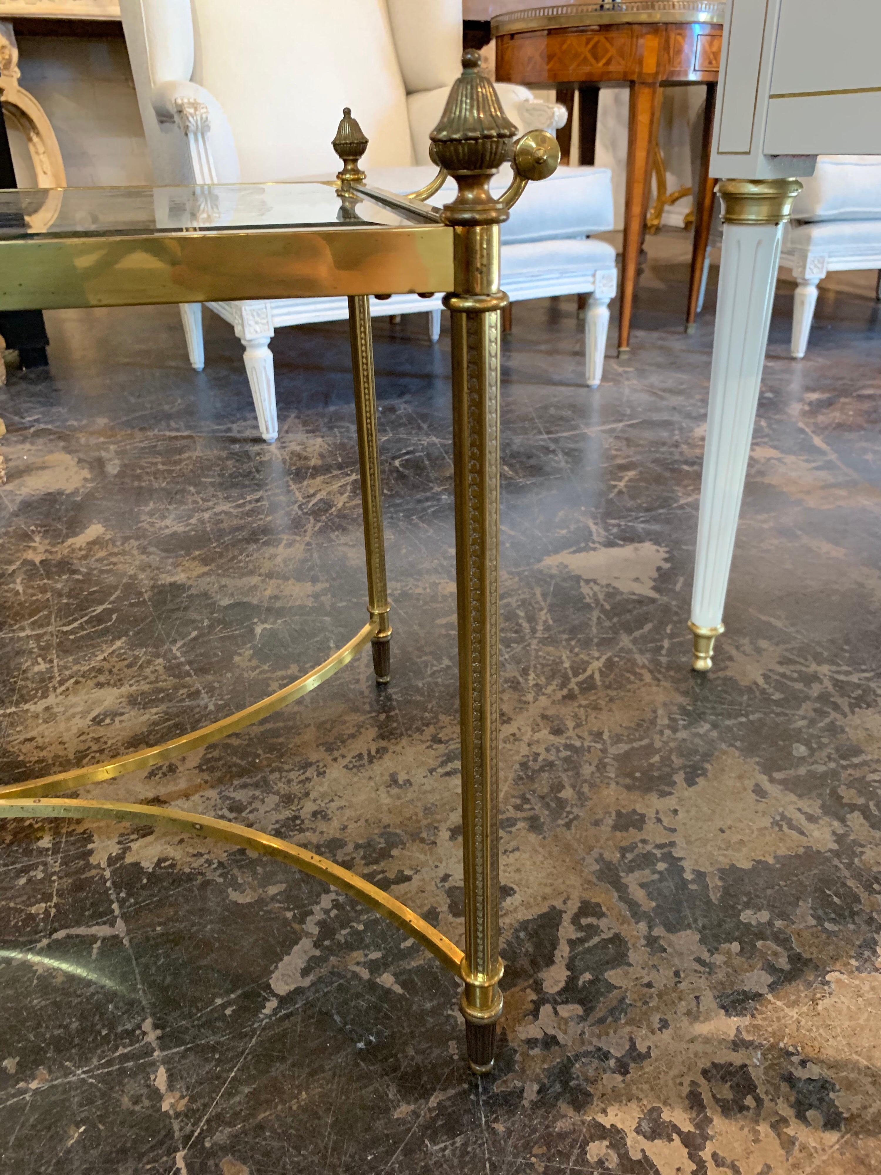 Very fine 1940s Jansen style brass cocktail with glass top. This table has nice details including finials at the corners. Creates a Classic look!