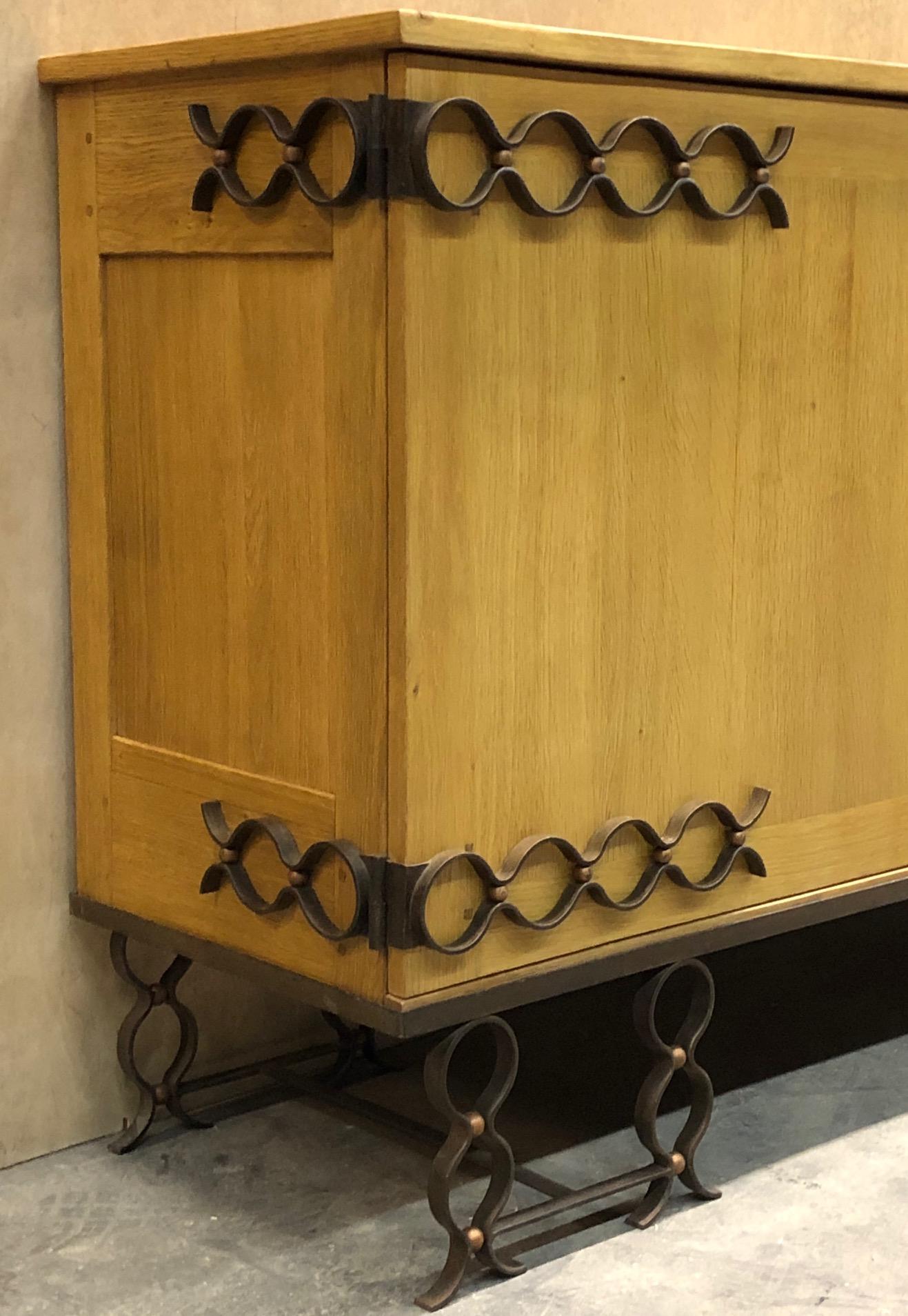 Rare oak buffet by Jean Royère. Cast iron make up the piece's legs and decorative accents in an elaborate wave-like pattern. This buffet was custom designed and produced in 1943 and was later on archived at the Musee des Arts Decoratifs in